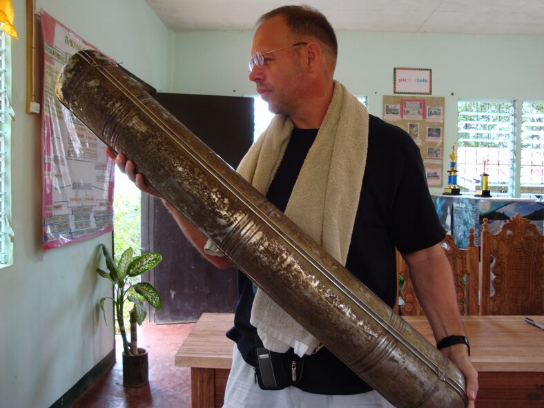 TACLOBAN, Philippines -- Crew member Robert Lucke holds an oxygen bottle from the 1940s during a mission to find the downed crew of a C-47 Skytrain that had crashed during World War II. A local resident claims that it was used to store vinegar. (Photo courtesy of Senior Master Sgt. Thomas Niznik/RELEASED)