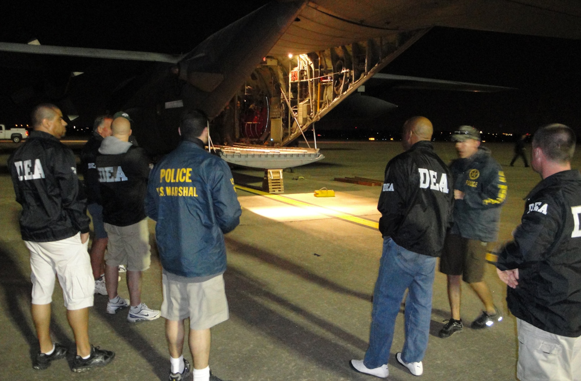Agents from the U.S. Department of Justice's Drug Enforcement Agency, U.S. Marshall's office and the DOJ's Criminal Division await the offloading of several pallets of seized gold, silver and jewels April 9 in Austin, Texas. The seize assets were part of a joint Panama-U.S. investigation into an international drug money laundering scheme in the Central American country. The Air Force Reserve's 302nd Airlift Wing was tasked with flying the seized precious metals and jewels back to the United States from Panama for further processing by Department of Justice agencies. (Courtesy photo/Drug Enforcement Agency)