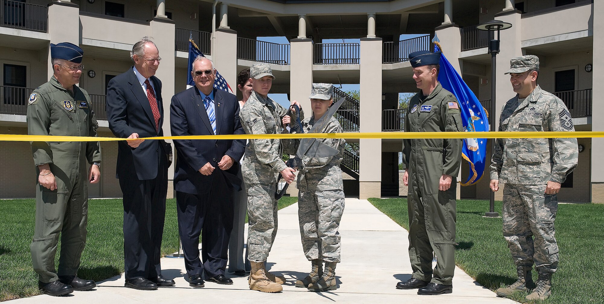 Wing leadership, distinguished visitors and Dover Airmen helped to cut the ribbon during the ceremony to officially open the Dorms-4-Airmen April 23. The $14 million-dollar dorm was completed after two years of construction. (U.S. Air Force photo/Brianne Zimny)