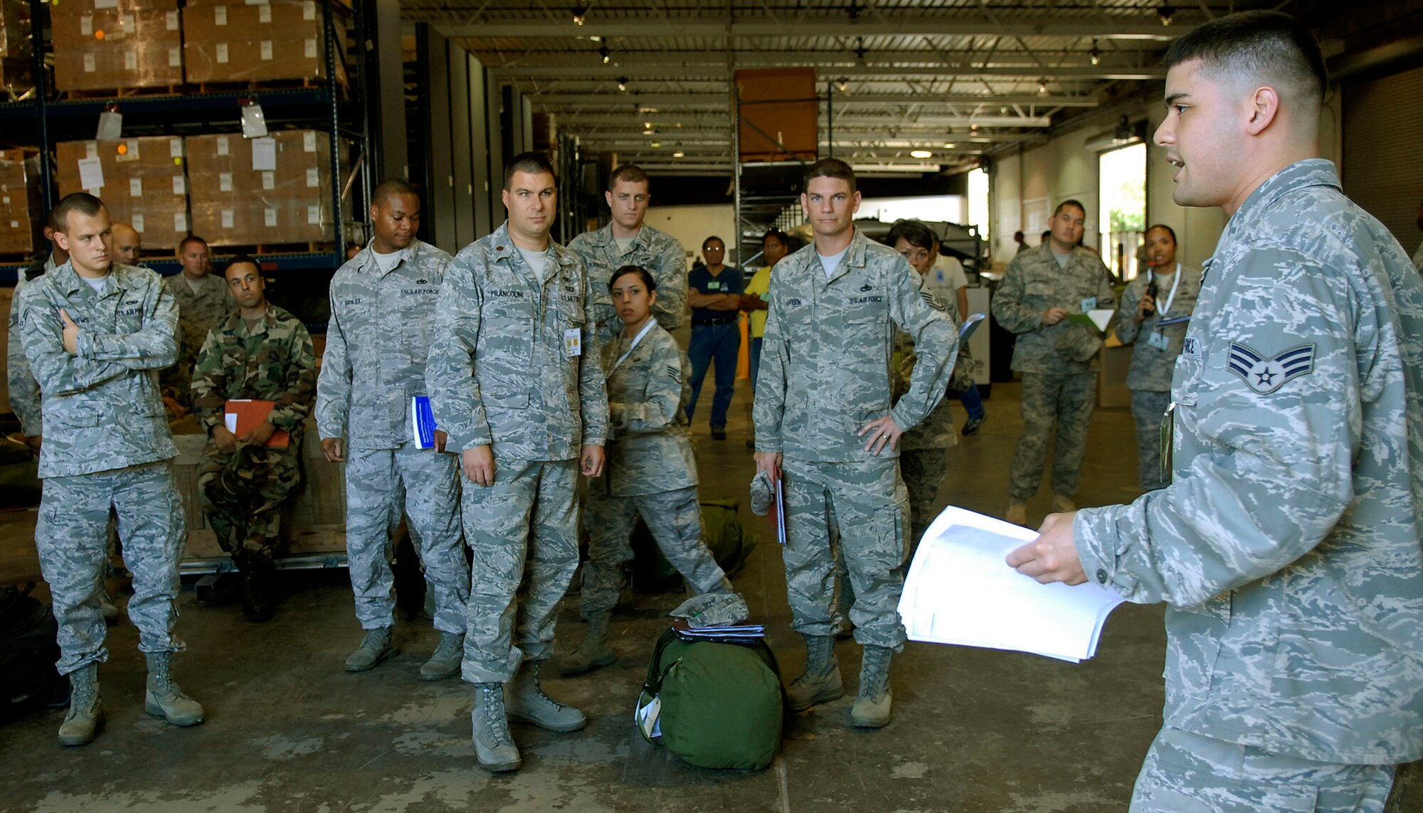 JOINT BASE PEARL HARBOR HICKAM, Hawaii--Senior Airman Daniel Galacgac, 15th Medical Group, explains the instructions on how to fill out a deployment bag checklist, to members of the 15th Airlift Wing's maintenance group during an Operational Readiness Exercise at the Personnel Deployment Function building here April 22. The PDF serves as the wing's last set of eyes ensuring all personnel are eligible for deployment. The ORE is designed to test 15th Airlift Wing's capabilities to respond to real world contingencies.  (U. S. Air Force photo/Tech. Sgt. Jerome S. Tayborn)