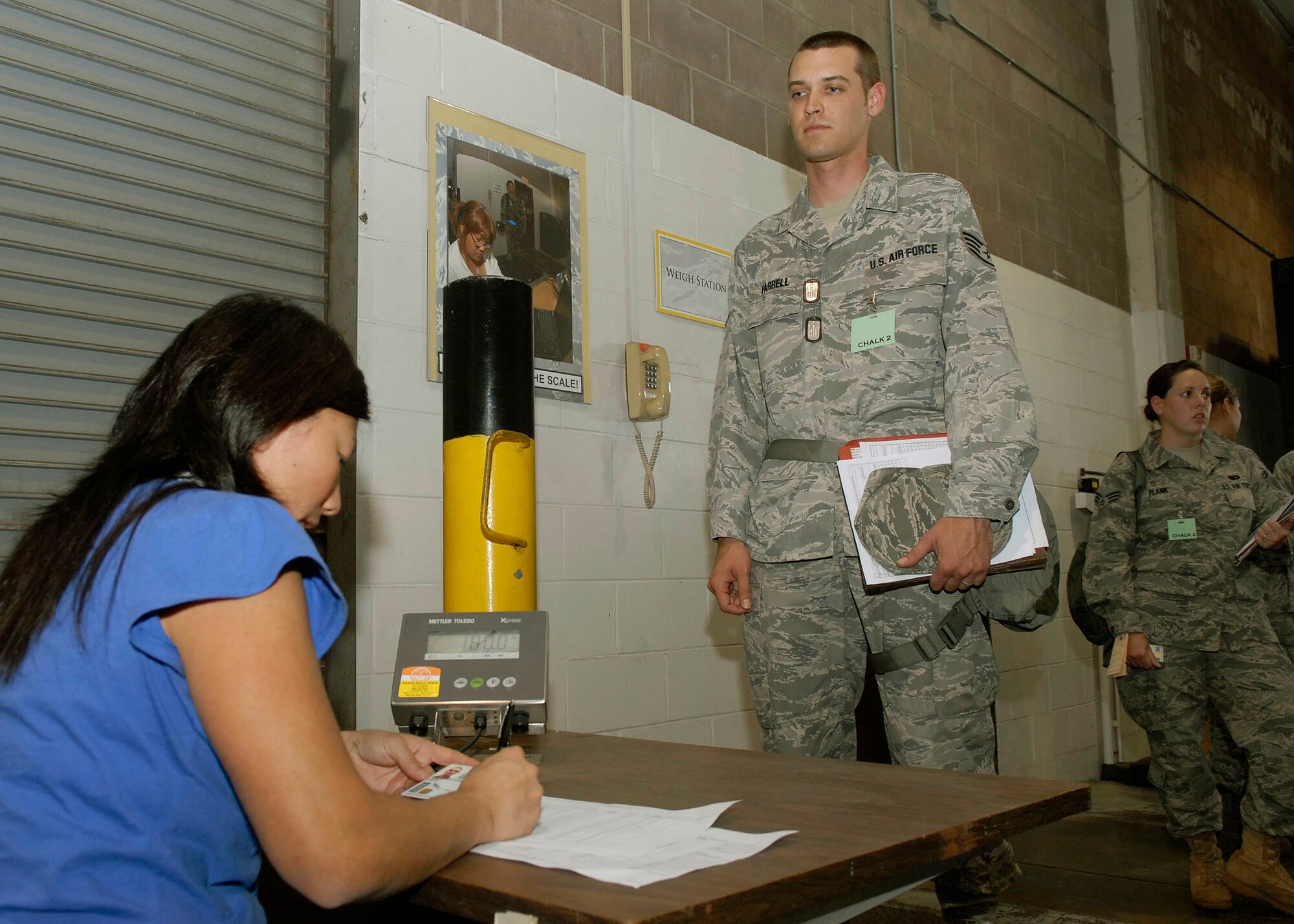 JOINT BASE PEARL HARBOR HICKAM, Hawaii--Betsy Yamaoka, 15th Services Squadron, weighs Staff Sgt. Cory Farrell, 15th Family Support Squadron, during an Operational Readiness Exercise at the Personnel Deployment Function building here April 22 here. The PDF serves as the wing's last set of eyes ensuring all personnel are eligible for deployment. The ORE is designed to test 15th Airlift Wing's capabilities to respond to real world contingencies.  (U. S. Air Force photo/Tech. Sgt. Jerome S. Tayborn)

