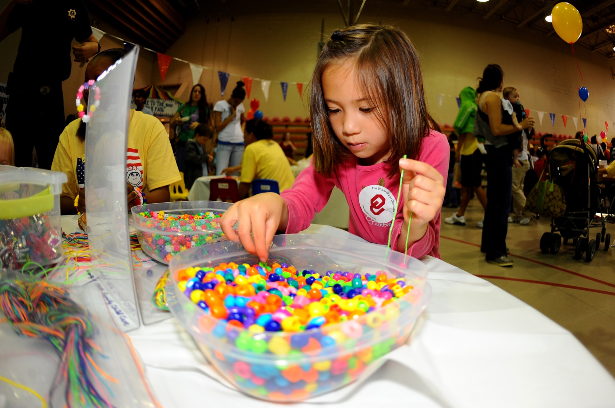 OFFUTT AIR FORCE BASE, Neb. -- 6-year-old Emma Conger, daughter of Navy Lt. Nathan Conger with U.S. Strategic Command, makes a necklace during the 2010 Family Fun Fair at the Youth Center here April 24. Hundreds of active-duty members and their families attended the event taking part in numerous activities including face painting, coloring, horseback riding and much more. U.S. Air Force Photo by Josh Plueger
