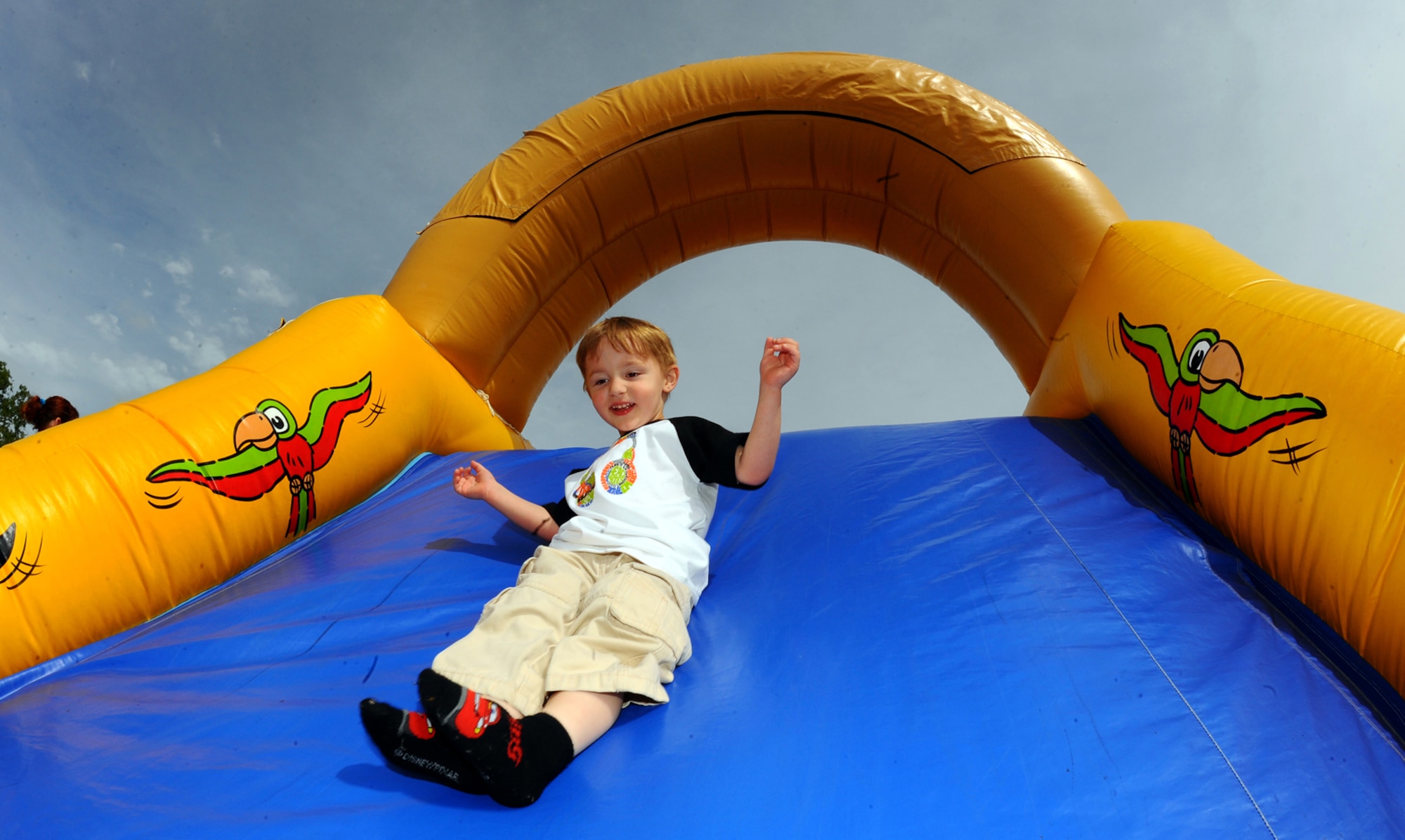 OFFUTT AIR FORCE BASE, Neb. -- Three-year-old Kevin Lee, son of Becka Dillingham with Offutt's Child Development Center, bounces down the slide of an inflatable bounce house at the 2010 Family Fun Fair at the Youth Center here April 24. Hundreds of active-duty members and their families attended the event where they took part in numerous activities including face painting, coloring, horseback riding and much more. U.S. Air Force Photo by Josh Plueger

