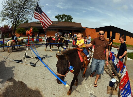 OFFUTT AIR FORCE BASE, Neb. - Ten-month-old Ian Gentry, with the assistance of his father Senior Airman Thomas Gentry, U.S. Strategic Command, rides a pony at the Family Fun Fair at the Youth Center here April 24. Hundreds of active-duty members and their families attended the event where they took part in numerous activities including coloring and face painting. U.S. Air Force Photo by Josh Plueger 
