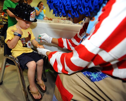 OFFUTT AIR FORCE BASE, Neb. -- Three-year-old Cameron Rulong, son of Staff Sgt. Jason Rulong, with the 1st Aircraft Maintenance Unit, gets a frog tattoo on his hand at the 2010 Family Fun Fair at the Youth Center here April 24. Hundreds of active-duty members and their families attended the event where they took part in numerous activities including face painting, coloring, horseback riding and much more. U.S. Air Force Photo by Josh Plueger. 
