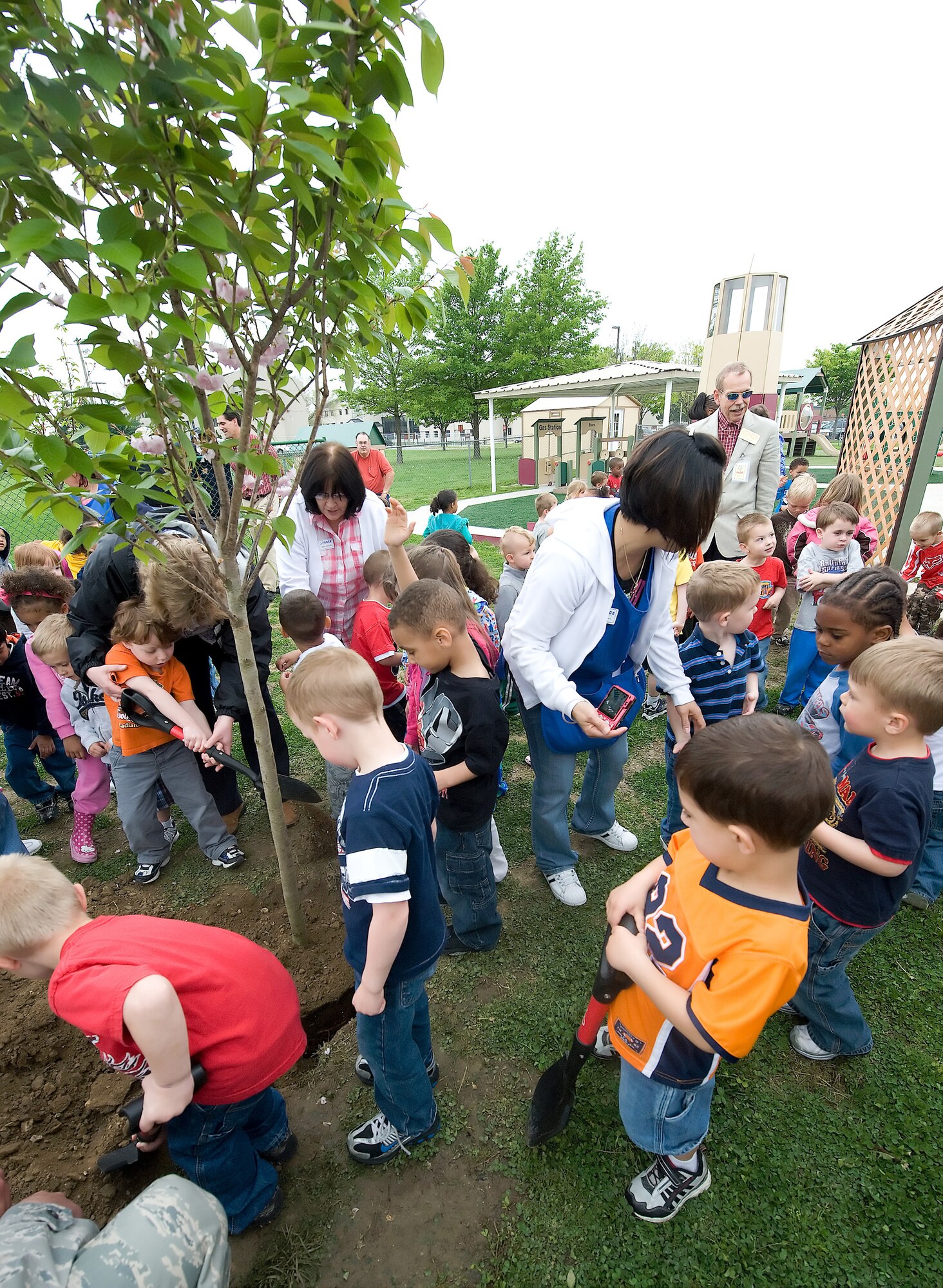Child Development Center children shovel dirt into the roots of a tree planted for the 40th anniversary of Earth Day. They got together with representatives from the Delaware Forest service and the installation to celebrate Earth Day. (U.S. Air Force photo/Brianne Zimny)