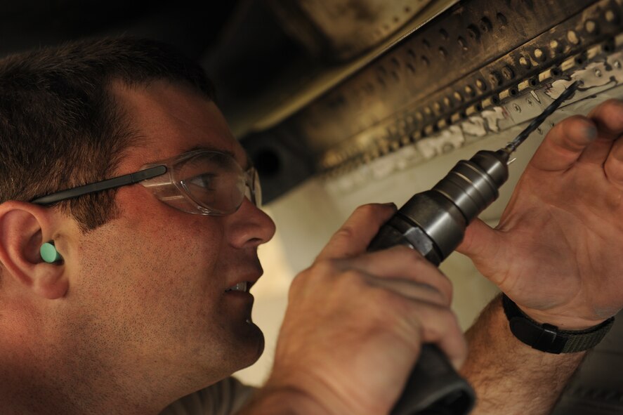 MOODY AIR FORCE BASE, Ga. -- Staff Sgt. James Anderson, 23rd Equipment Maintenance Squadron sheet metal shop member, drills out the rivets that hold a broken nacelle door hinge to an A-10C Thunderbolt II aircraft here April 1.  Sergeant Anderson had to drill the rivets out and then remove them with a hammer and punch tool. (U.S. Air Force photo by Airman 1st Class Benjamin Wiseman/RELEASED)