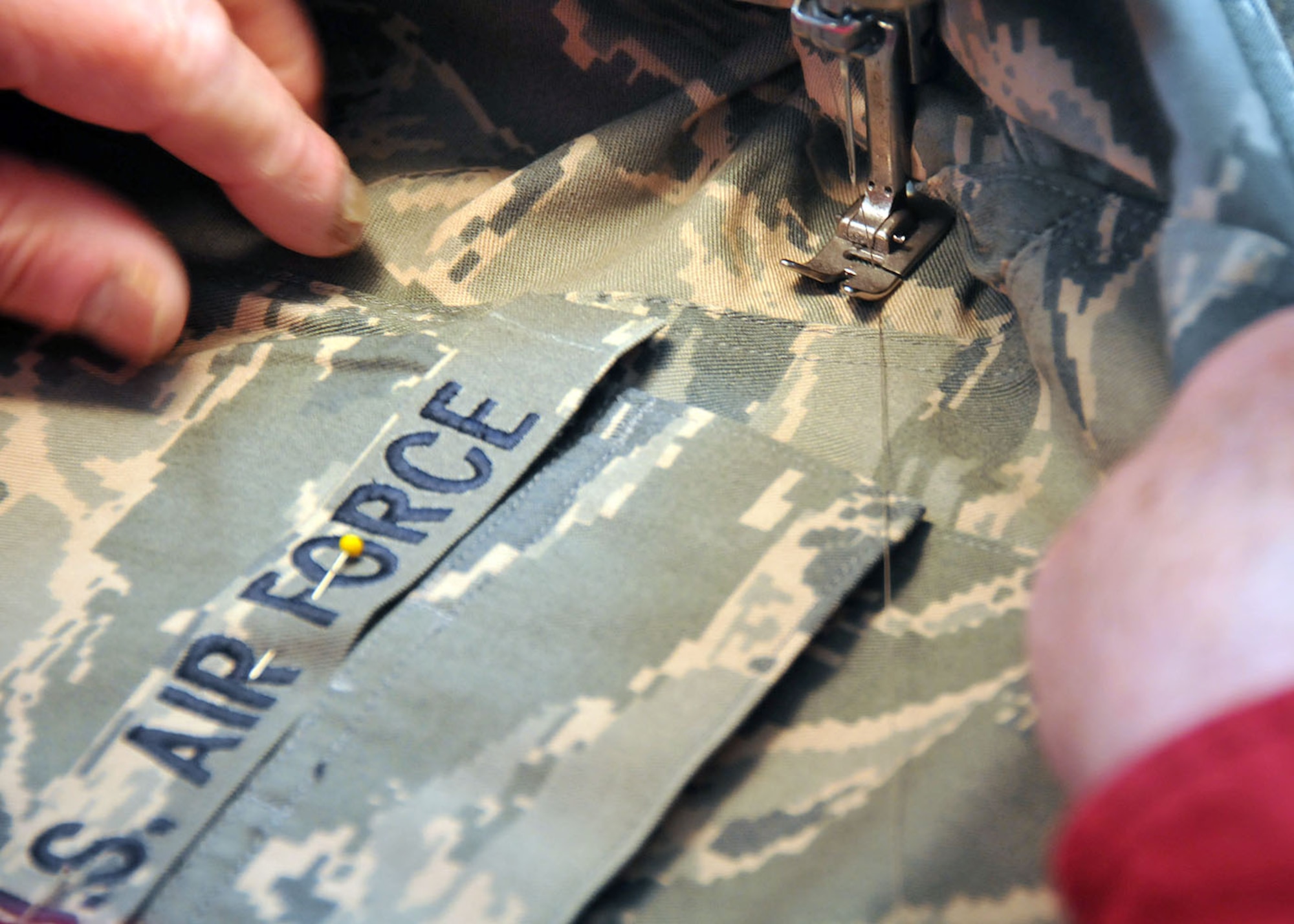 Hans Billerbeck sews on the US AIR FORCE patch.  Billerbeck estimates that, at four uniforms per Airmen, he has sewn patches, stripes and name tapes on nearly 800 new ABUs for 128th Airmen.