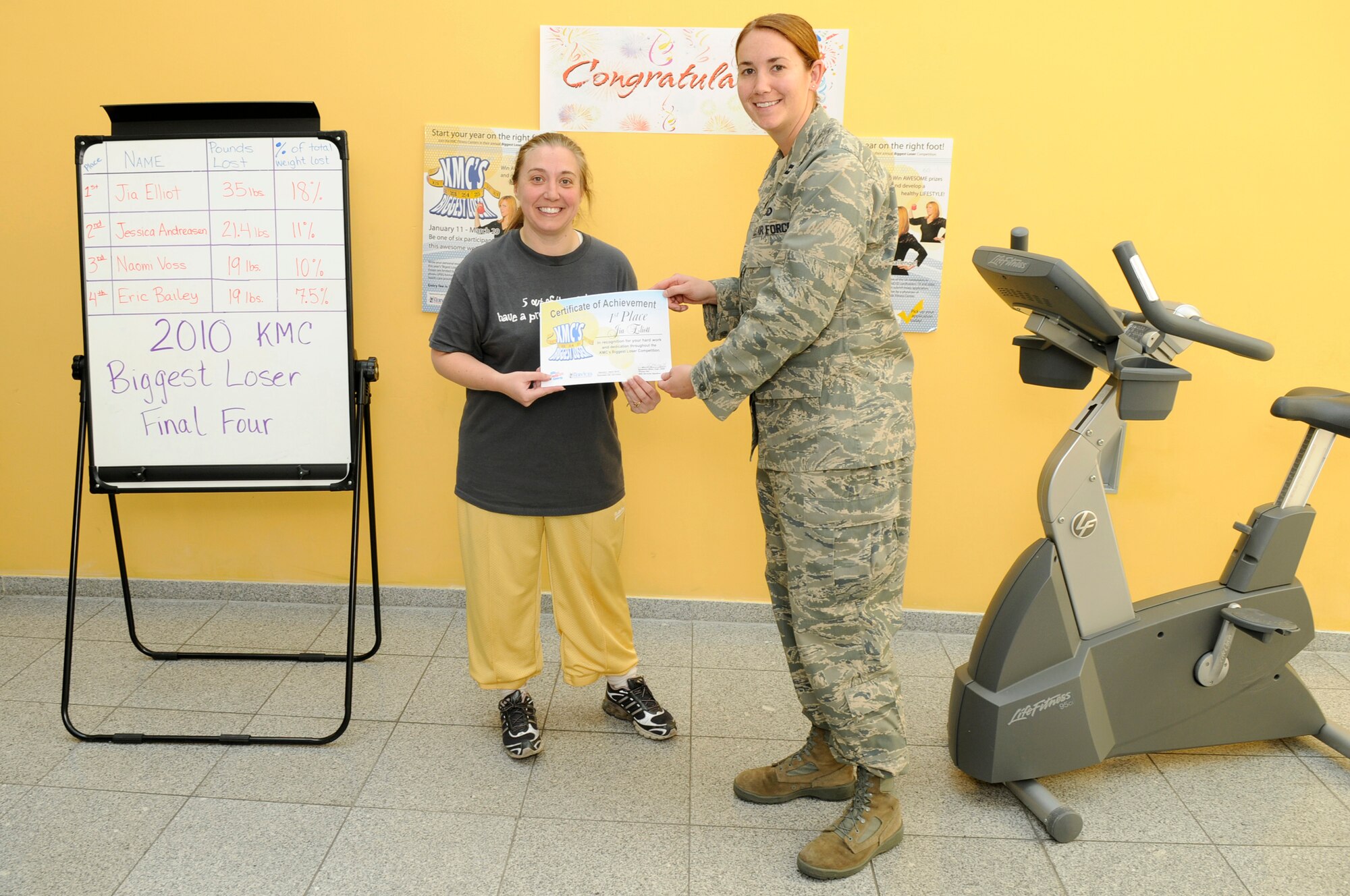Jia Elliott, wife of U.S. Air Force Tech Sgt. Rob Elliott, 435th Construction and Training Squadron, receives a 1st-place certificate from Capt. Samantha Miller, 86th Services Squadron officer in charge of fitness, Southside Fitness Center, Ramstein Air Base, Germany, April 23, 2010. Mrs. Elliot was recognized for her hard work and dedication throughout the 2010 Kaiserslautern Military Community's fourth-annual Biggest Loser Competition. (U.S. Air Force photo by Airman 1st Class Brittany Perry)