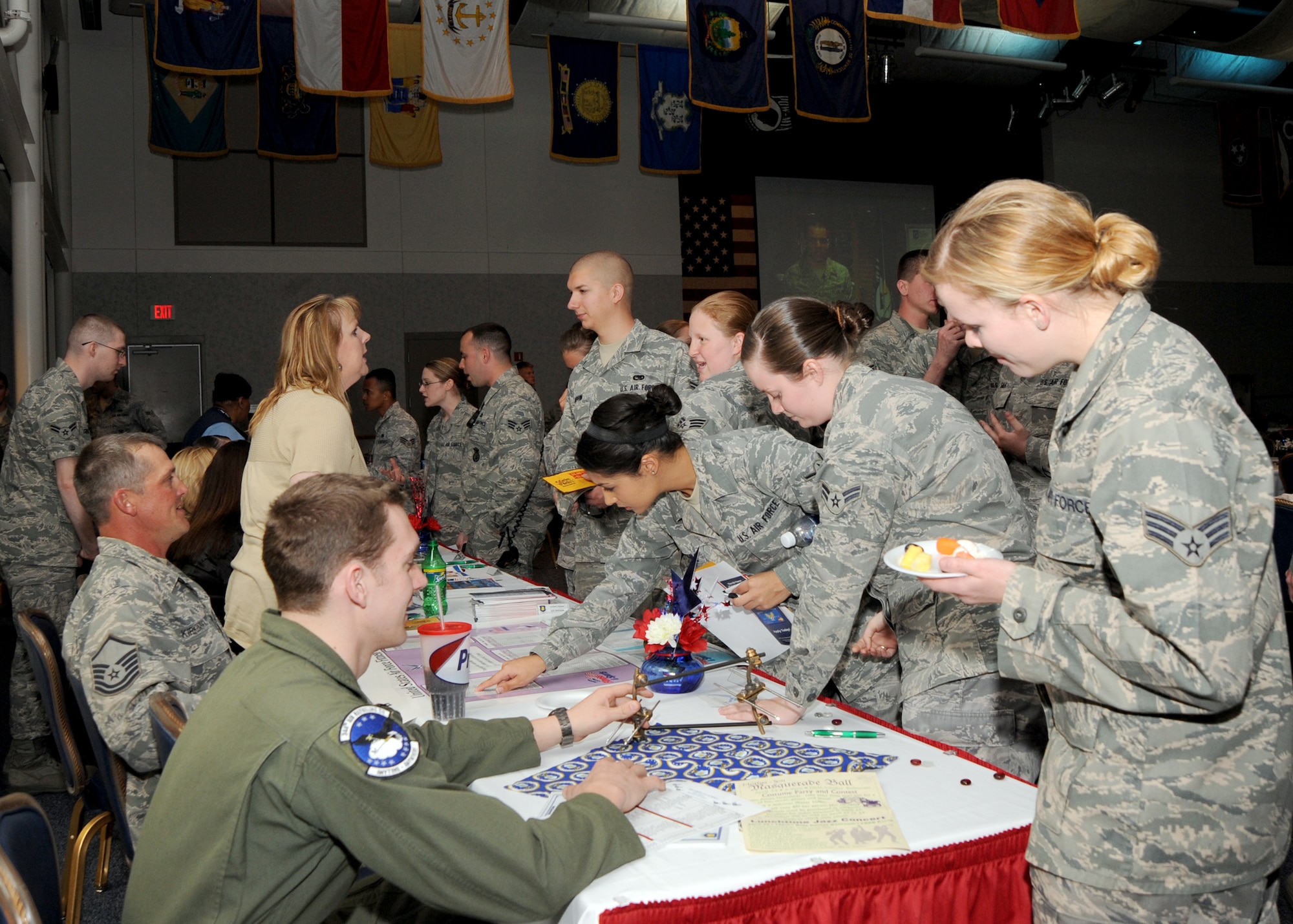 Airmen surround an informational table that included pamphlets and representatives from McConnell’s Health and Wellness Center, Honor Guard, New Parents Support Group and a variety of other morale and readiness programs available at the Robert J. Dole Community Center ballroom, April 20, 2010, McConnell Air Force Base, Kan. During the summit, Airmen were allowed to obtain additional information about the programs they were interested in. Approximately 240 Airmen attended the Junior Enlisted Airman Summit. (U.S. Air Force photo/Airman 1st Class Andrea Salazar)