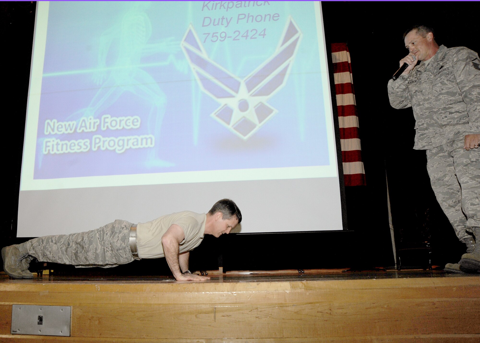 Col. James Crowhurst, 22nd Air Refueling Wing commander, demonstrates a proper push-up as Master Sgt. Mark Kirkpatrick, 22nd Force Support Squadron fitness assessment cell superintendent, observes in front of approximately 240 Airmen April 20, 2010, McConnell Air Force Base, Kan. At the summit Colonel Crowhurst emphasized the importance of good push-up form in preparation for the new Air Force physical fitness standards that will take effect July 1, 2010. (U.S. Air Force photo/Airman 1st Class Andrea Salazar)