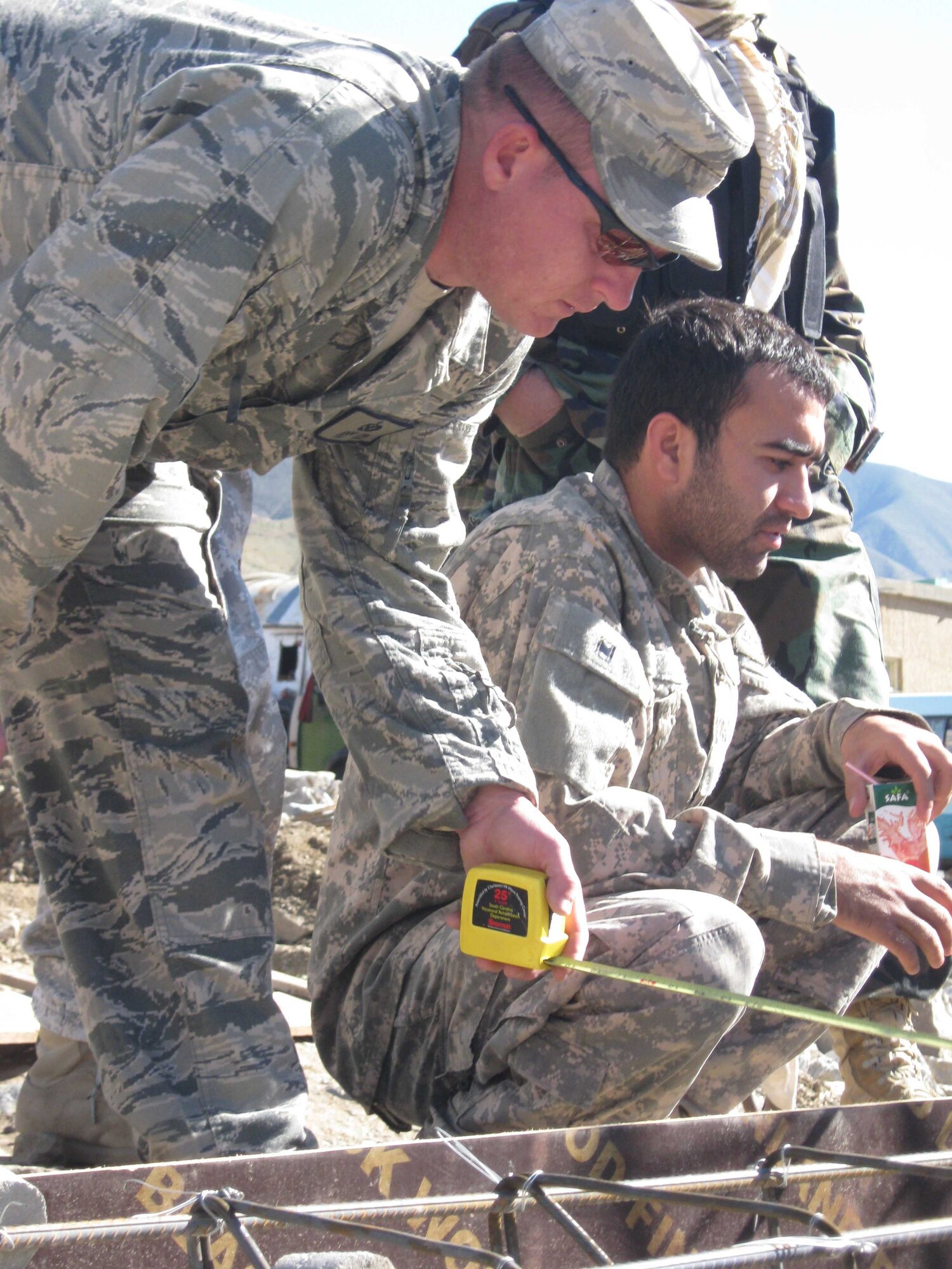 Tech. Sgt. Jeremy Louk (front), Provincial Reconstruction Team Panjshir civil engineer deployed from Barksdale Air Force Base, La., measures rebar during a quality control visit to the Anaba District Court work site, Panjshir Province, Afghanistan, April 19. Louk and some other PRT engineers visited five work sites and held two meetings during a one-day mission. (U.S. Air Force Photo by 2nd Lt. Jason Smith, PRT Panjshir Public Affairs)