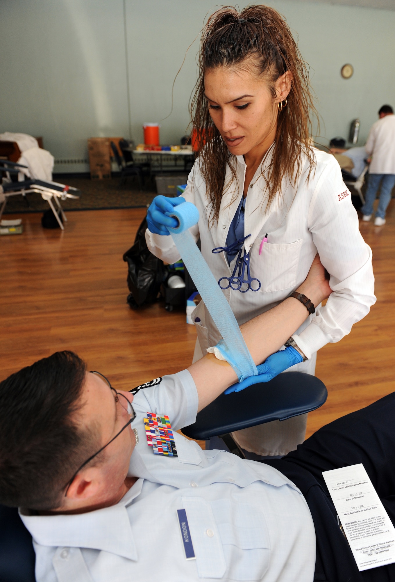 MOUNTAIN HOME AIR FORCE BASE, Idaho -- Reiko Aduara, Madigan Army Medical Center lab technician from Ft. Lewis Washington, wraps a bandage around the arm of Chief Master Sgt. Vance Kondon, 366th Operations Group superintendent, during the Armed Services Blood Program blood drive at the community center April 19. The goal for the two-day blood drive was to collect 200 units of blood. According to www.militaryblood.dod.mil, the ASBP plays a key role in providing quality blood products for service members and their families in both peace and war. (U.S. Air Force photo by Airman 1st Class Debbie Lockhart)