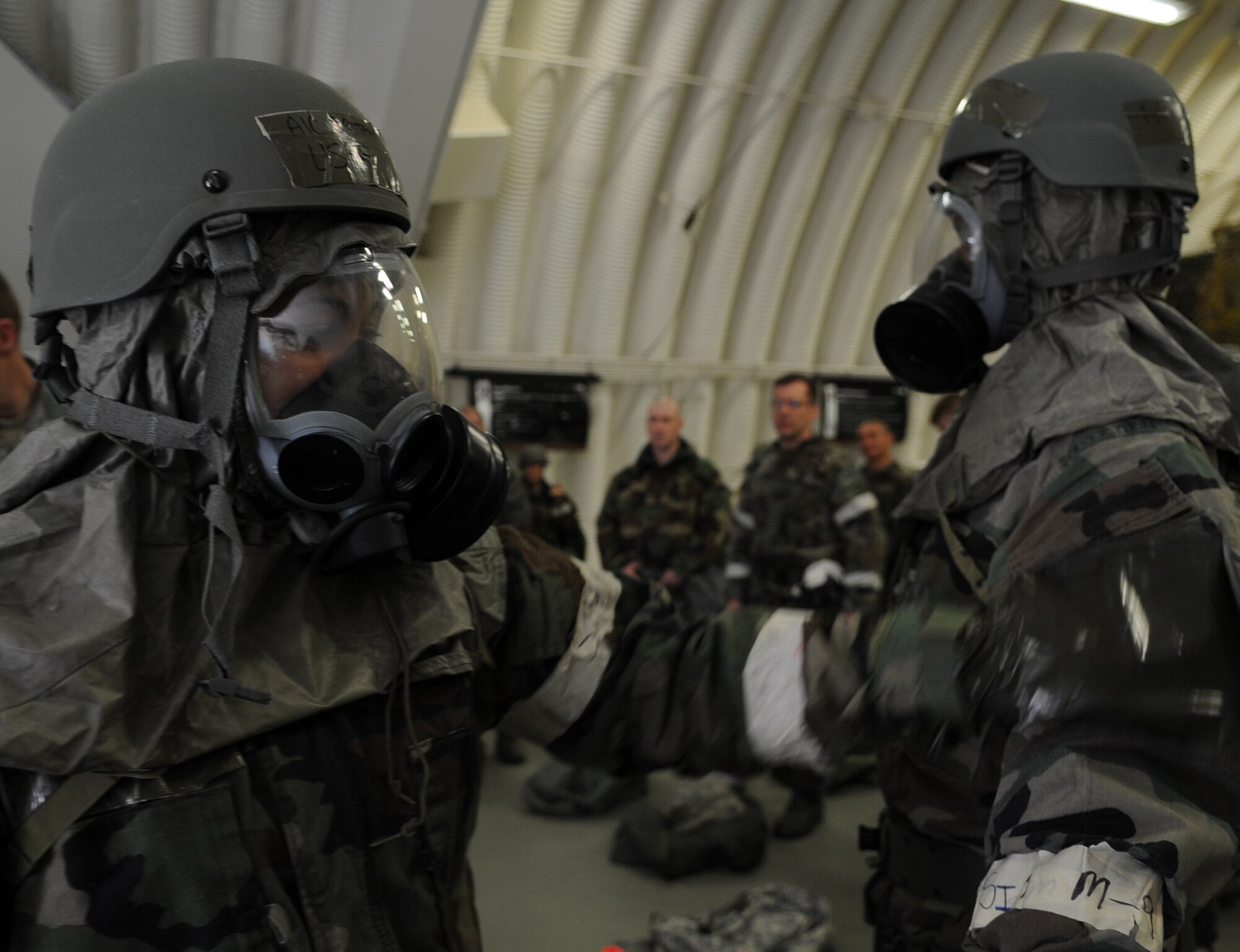 U.S. Air Force Airman 1st Class Brittany Perry and Desiree Esposito, 86th Airlift Wing Public Affairs photographers, demonstrate the proper way to check for contamination of chemical gear during chemical, biological, radiological, nuclear, and high yield explosives training, Ramstein Air Base, Germany, April 23, 2010.  Preparation for the ORI allows Air Force members to build on strengths and indentify weaknesses in order to better support future missions. (U.S. Air Force Photo by Airman 1st Class Caleb Pierce)