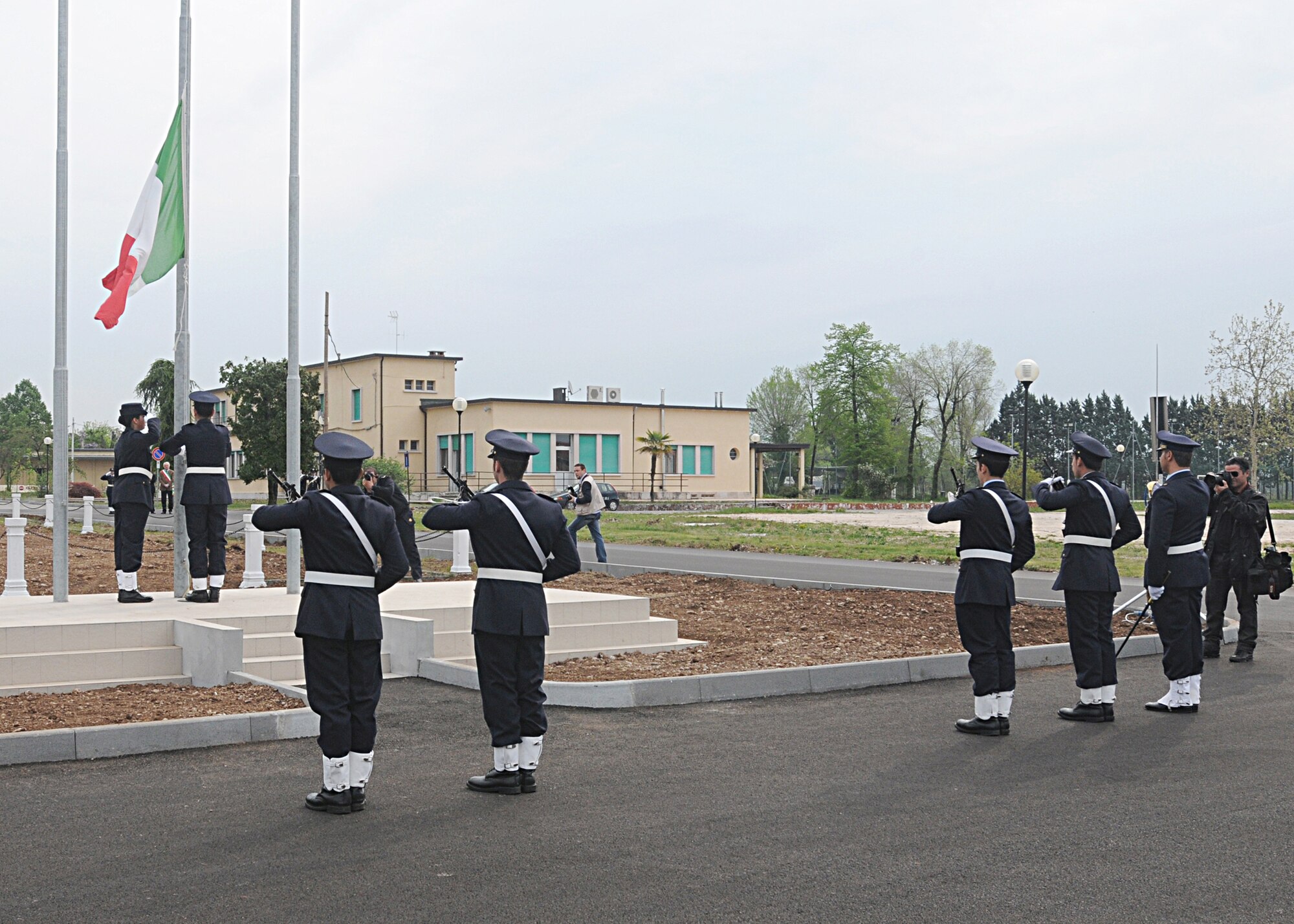 Italian Honor Guardsmen raise the Italian flag during a reveille ceremony April 23 at the newly renovated Italian Air Force headquarters building in Area F.  After the ceremony, the Italian aerobatic team, Frecce Tricolori, performed a practice run for Aviano residents.  (U.S. Air Force photo by Senior Airman Tabitha M. Mans)