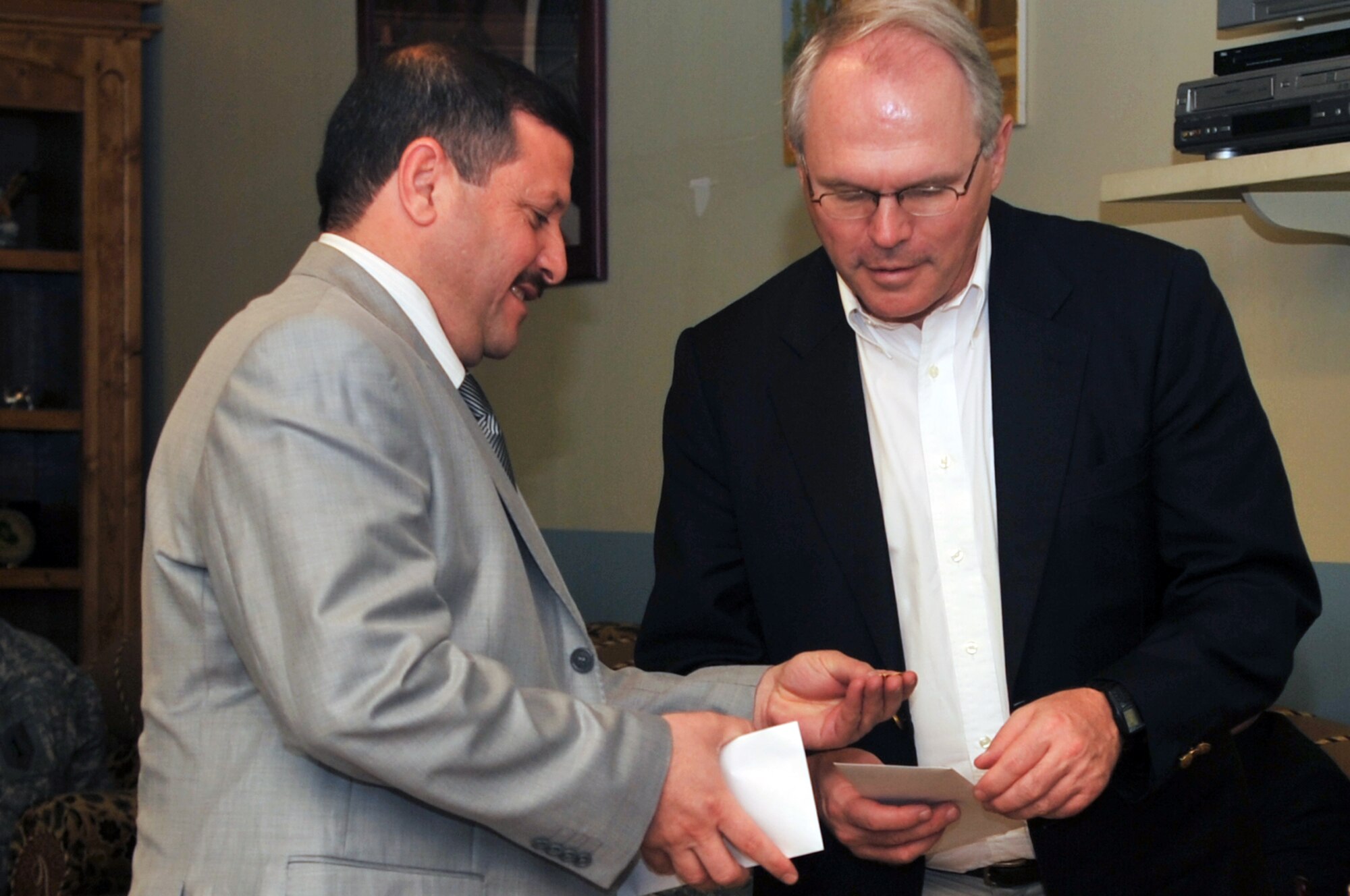 A local national shows his appreciation to United States Ambassador to Iraq Christopher Hill by giving him a pin during his visit to the Provincial Reconstruction Team at Joint Base Balad, Iraq, April 23, 2010. As the August U.S. troop reduction date nears, PRT is working around the clock to prepare Iraq for its post drawdown future. During his visit, the ambassador was able to see the teams work first hand as he met with many Iraqi community leaders. (U.S. Air Force photo/Senior Airman Brittany Y. Bateman/Released)