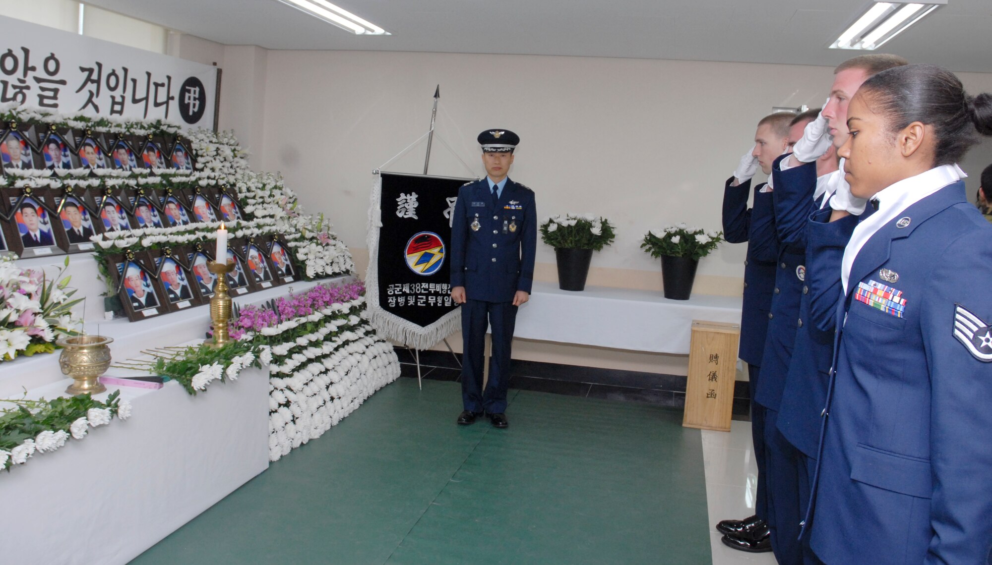 Kunsan Air Base Honor Guard Team salutes as they pay their respects to mourn the Republic of Korea Navy sailors killed in the sinking of the Cheonan naval patrol ship last month. 

The Republic of Korea government has declared April 25-29 a 5-day mourning period for the sailors. 

Places have been set up at military bases around the country where people can go and express their condolences. 

The designated location here at Kunsan AB is at the ROKAF visitor center located at the back gate. A white banner of mourning is displayed on the front of the building.

Anyone wishing to express their condolences at the loss of our Korean Navy allies can do so at the visitor center between the hours 9 a.m. - 9 p.m., April 25 - 29. 

Flowers will be available to lay as a memorial to the fallen sailors.
Dress will be uniform of the day. (U.S. Air Force photo/Staff Sgt. Darnell T. Cannady)




