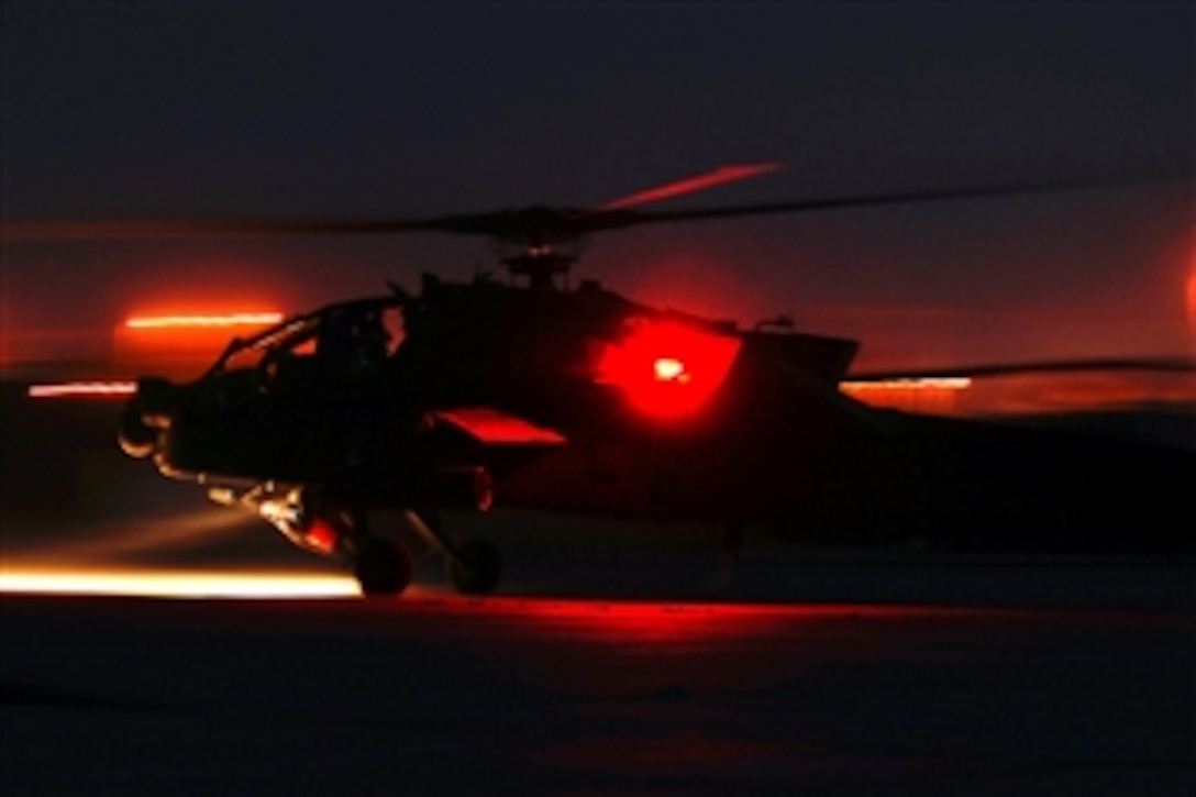 An AH-64 Apache attack helicopter makes its way down the flight line departing on a night reconnaissance mission on Camp Taji Army Airfield, Iraq, April 18, 2010. The Apache crew is assigned to the 1st Infantry Division's Combat Aviation Brigade.