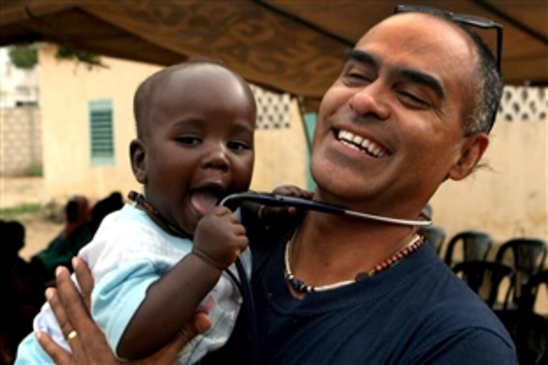 U.S. Navy Cmdr. Antonio Rodriguez, senior medical officer for Africa Partnership Station West, smiles as he holds a Senegalese baby during a medical outreach project in Noto Gourey Diame, Senegal, April 19, 2010. Rodriguez is part of a 16-member team of U.S. Navy and Air Force medical and dental professionals who have treated more than 2,000 patients in a four-day period.