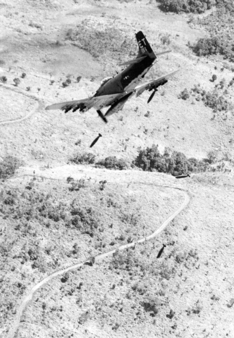 A single-seat A-1H aircraft flies through the air.