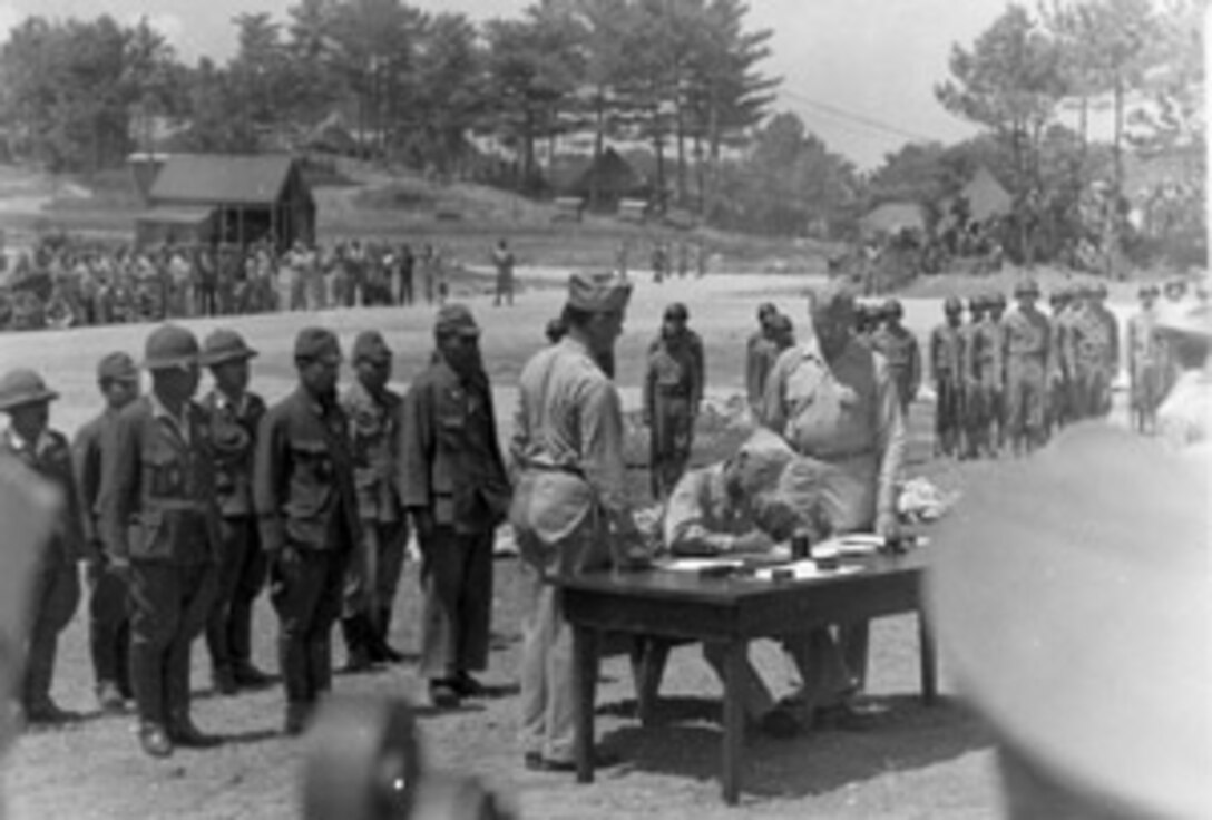 Japanese surrender, signing of documents ceremony, American Representative signing the document.  Ted J. Osenko Photograph Collection.