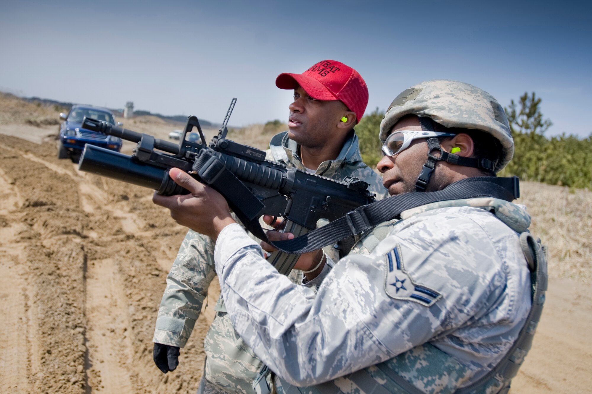 MISAWA AIR BASE, Japan -- Airman 1st Class Demarcus Harris, 35th Security Forces Squadron senior-force patrolman, fires an M203 grenade launcher with guidance from Staff Sgt. Jermaine King, 35th SFS combat-arms instructor, April 27 at Draughon Range. The training was a pre-deployment requirement for some of the 35th SFS Airmen who participated in the course. For others, the training was necessary to perform base-security post operations with the M203. (U.S. Air Force photo/Senior Airman Jamal D. Sutter)