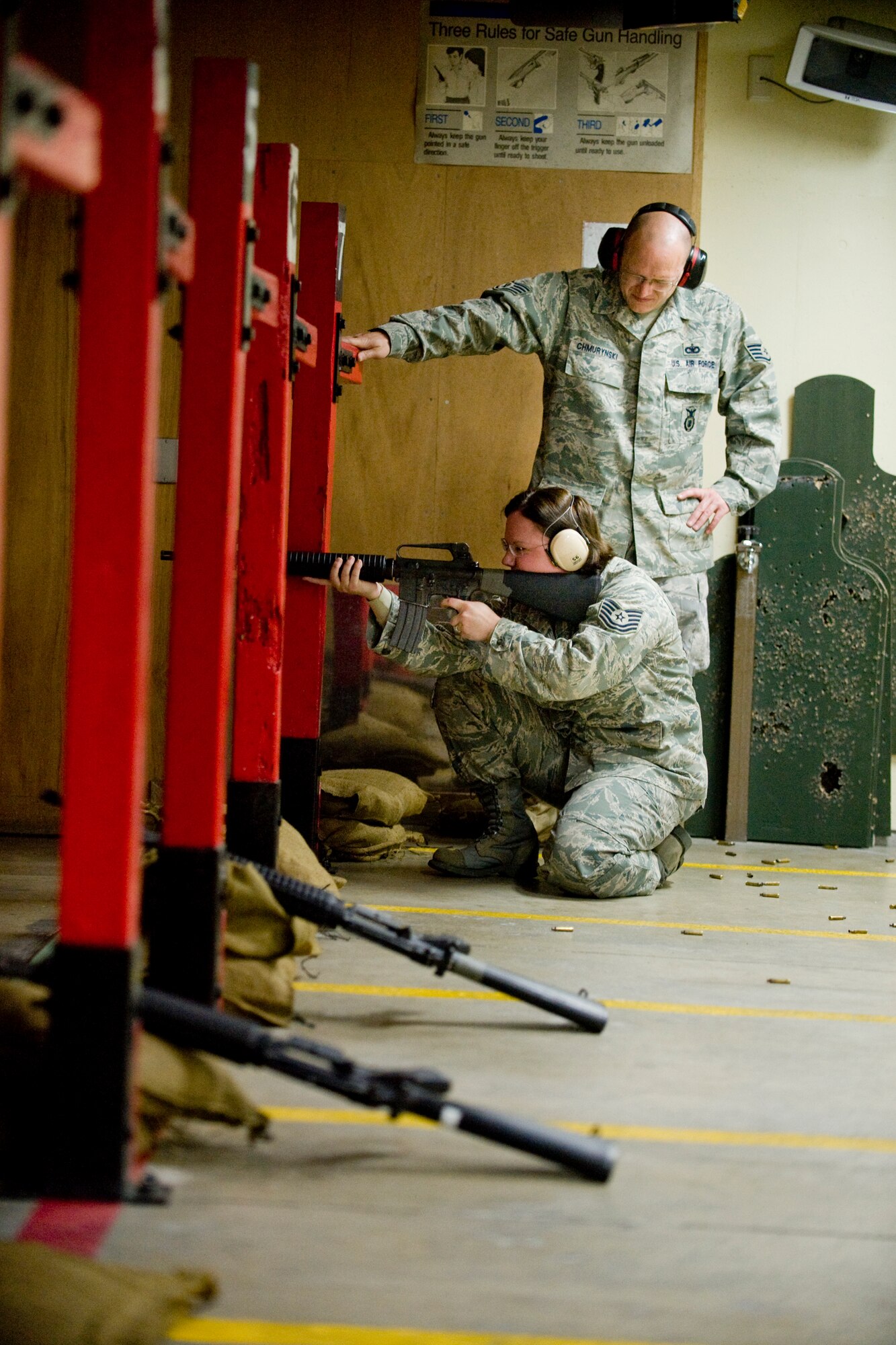 MISAWA AIR BASE, Japan -- Tech. Sgt. Tracy Zeece, 35th Fighter Wing military justice NCO in charge, fires an M4A1 in the kneeling position with guidance from Staff Sgt. Theodore Chmurynski, 35th Security Forces Squadron combat-arms instructor, April 27 at the combat arms training and maintenance range. Combat-arms students are required to shoot in several different firing positions to familiarize themselves with weapons in preparation for upcoming deployments. (U.S. Air Force photo/Senior Airman Jamal D. Sutter)