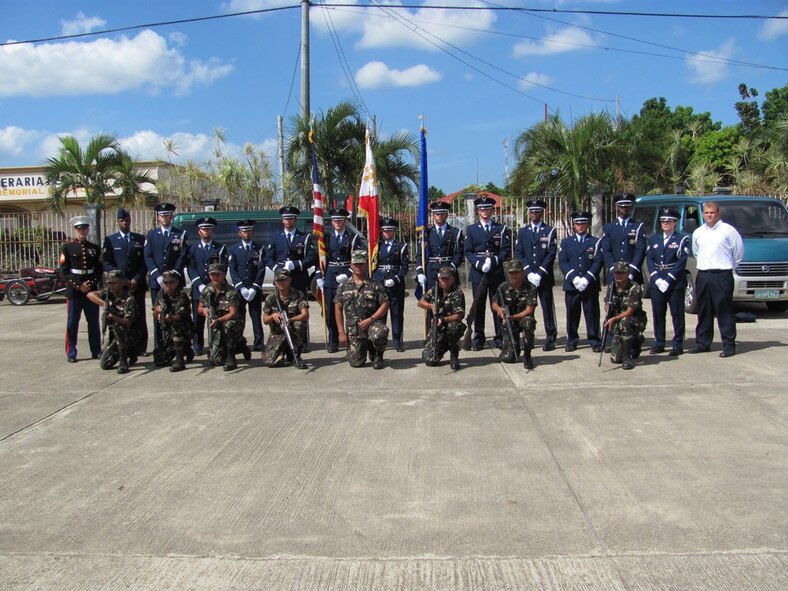 Airmen from the Kadena Honor Guard, bugler Marine Sgt. Aaron Wagners, and a firing team from the Armed Forces of the Philippines pose together following the funeral of an Air Force NCO in the Philippines. Several U.S. and Philippine organizations worked together to arrange for the burial of the U.S. Airmen, fulfilling the wishes of his family. (U.S. Air Force photo / Tech. Sgt. Brian Roberts)