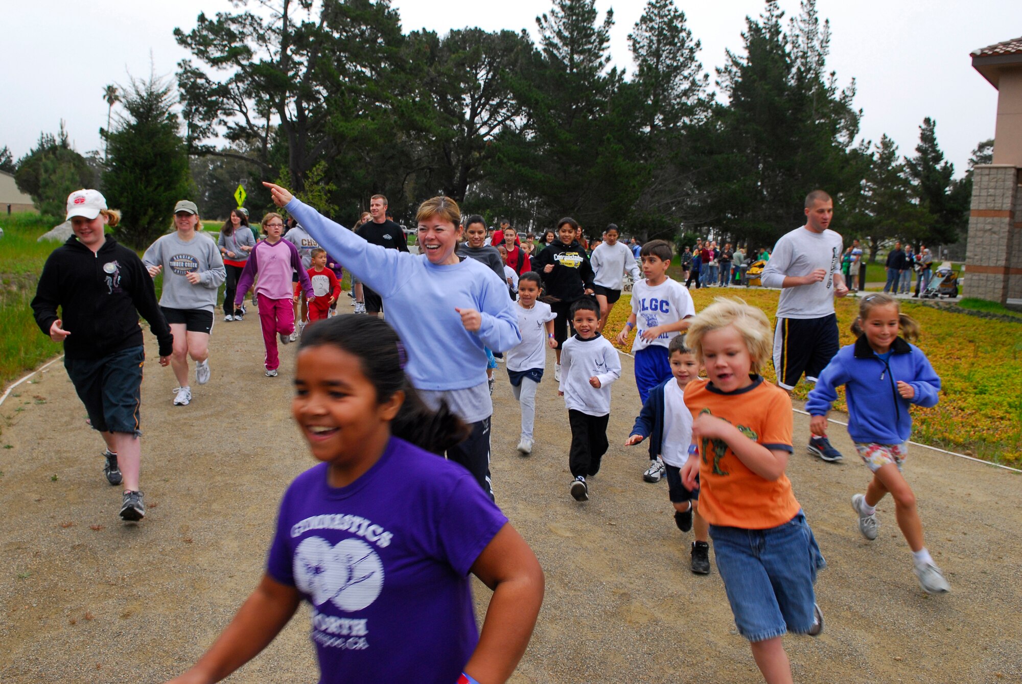 VANDENBERG AIR FORCE BASE, Calif. -- Airmen and their dependents run past the base fitness center during the Team Vandenberg Kids' Carnival here Saturday, April 24, 2010.  The carnival was aimed to promote awareness for the month of the military child, child abuse awareness, sexual assault awareness and alcohol awareness.  (U.S. Air Force photo/Senior Airman Andrew Satran) 

 

 