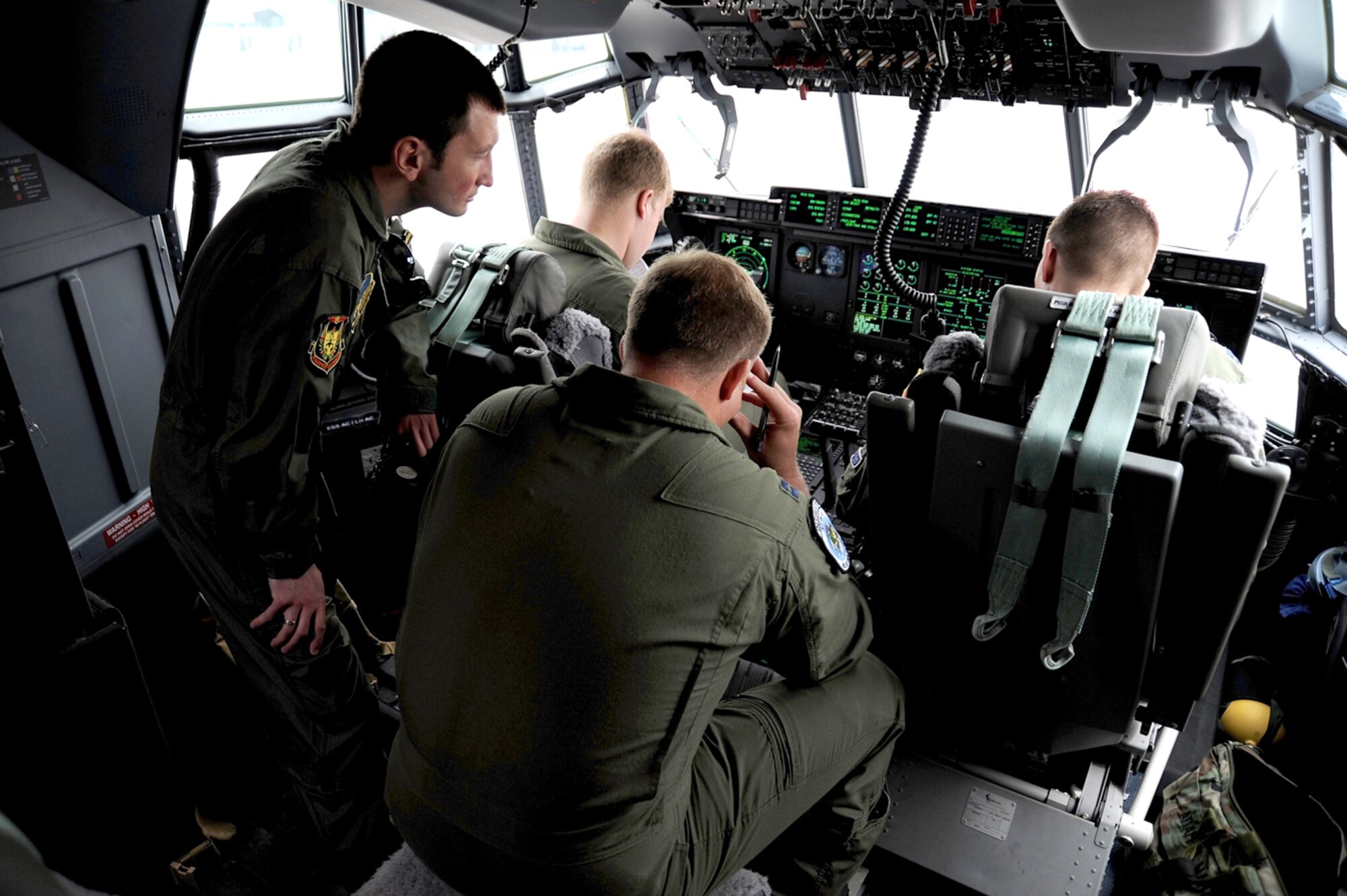 Bulgarian Air Force Lt. Hristo Valev looks over the shoulders of Capt. Jeff Davis, 1st Lt. Scott Lichtwardt and Capt. Adam Wantuck as they complete startup checks on a C-130 Hercules during Exercise Thracian Spring 2010 April 24, 2010, at Plovdiv Airport in Bulgaria. Lieutenant Valev is an Mi-24 pilot with the Bulgarian 24th air force and Captains Davis and Wantuck and Lieutenant Lichtwardt are all from the 37th Airlift Squadron. (U.S. Air Force photo/Master Sgt. Quinton T. Burris)
