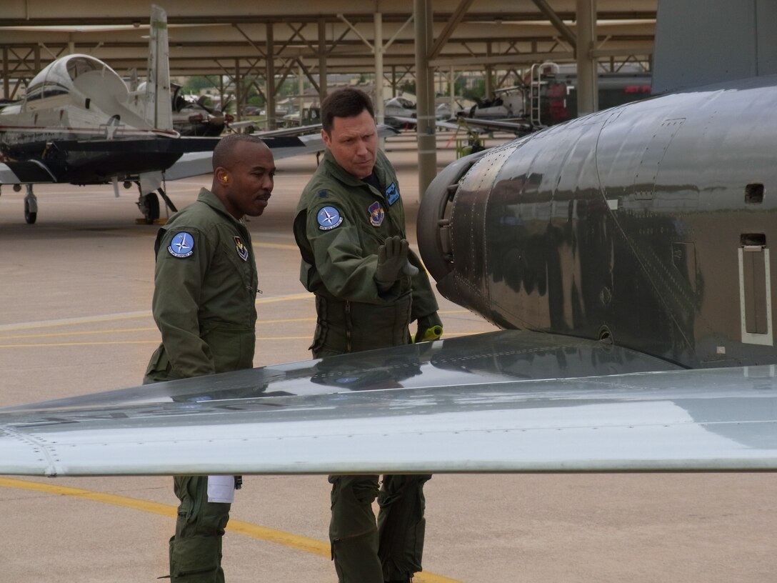 The 80th Flying Training Wings first command chief learns how to perform a preflight inspection prior to taking off for his orientation flight April 21, 2010.  Chief Master Sgt. Phillip Browning (left), flew for the first time in his 27-year Air Force career with Lt. Col. Barry Cook (right), 80th Operations Support Squadron commander. (U.S. Air Force Photo/Tech Sgt. Kenyun Willis) 