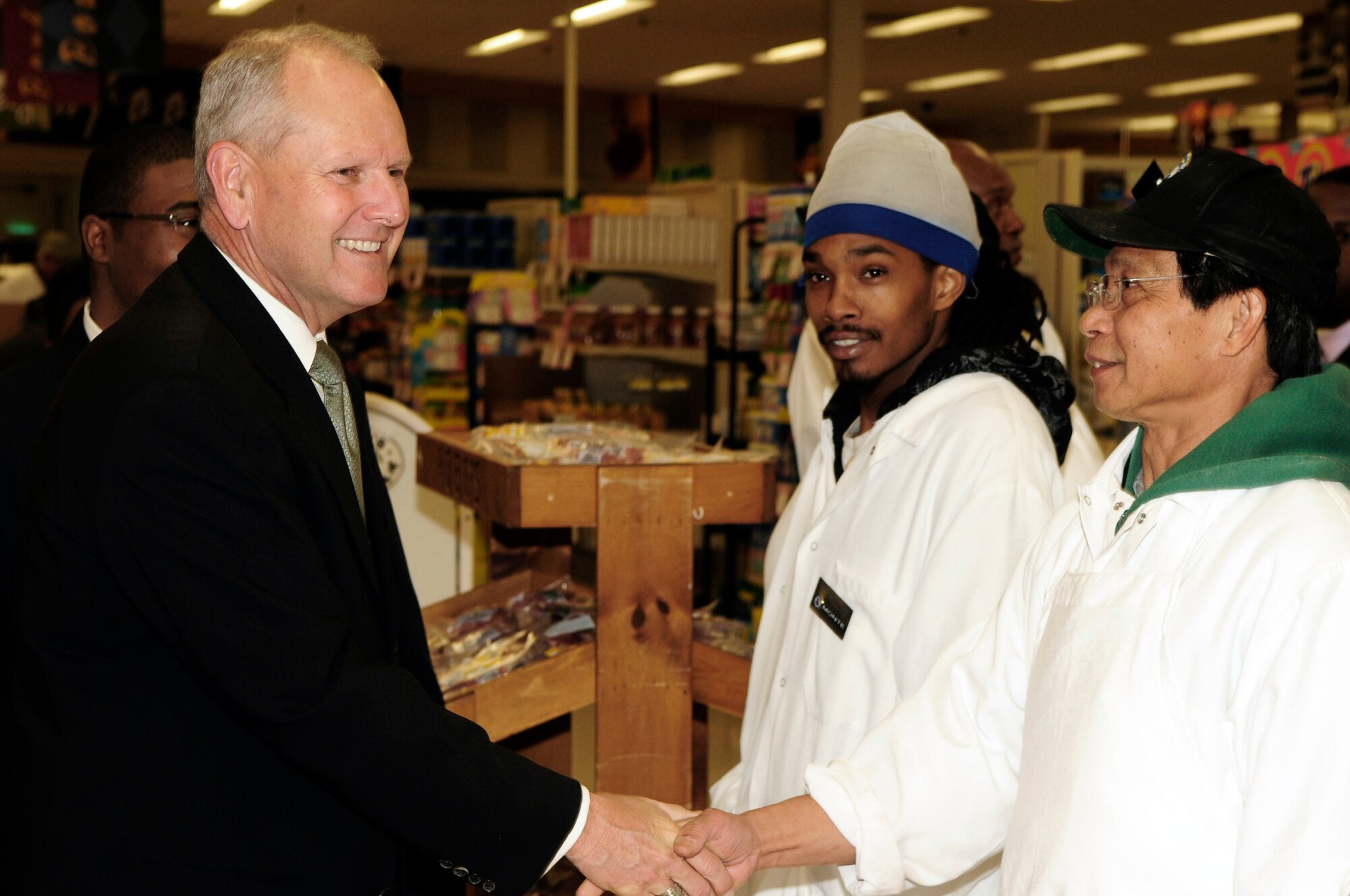 Philip Sakowitz, Jr., director and chief executive officer of the Defense Commissary Agency, speaks to Monte McNair and Federico Firme, Bolling AFB Commissary employees, April 24 at the BollingCommissary. Mr. Sakowitz took the day to visit Air Force commissaries in the National Capital Region. (U.S. Air Force photo by Staff Sgt. Raymond Mills)