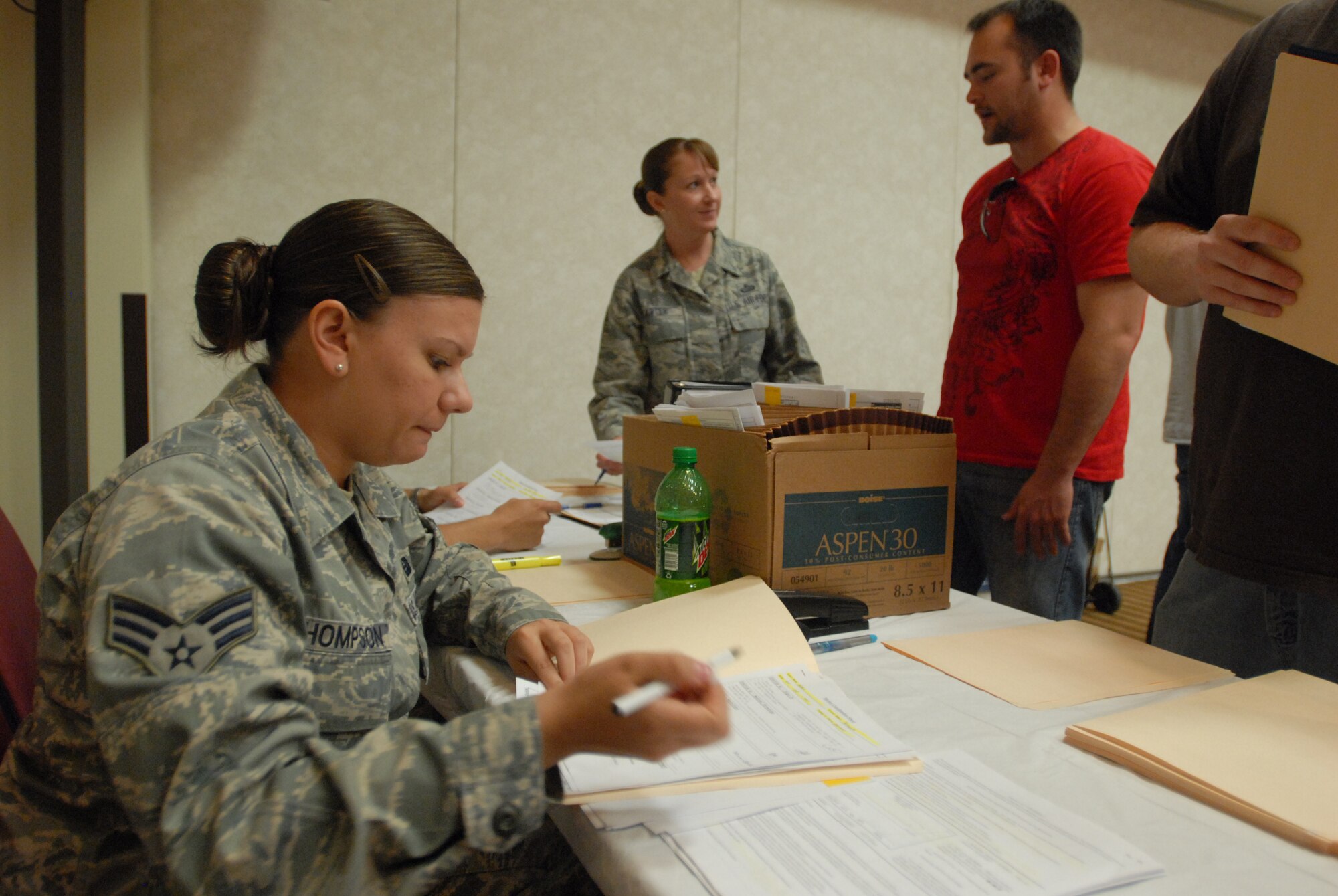 Senior Airman Christian Thompson, 17th Force Support Squadron, collects a completed checklist from a member of the Individual Ready Reserve while Master Sgt. Stephanie Carter assists another IRR member during an IRR Muster at Goodfellow AFB, Texas April 23.  A muster is held each year for individuals in the IRR to update personal information and receive information on benefits. (U.S. Air Force photo by Master Sgt. Randy Mallard)