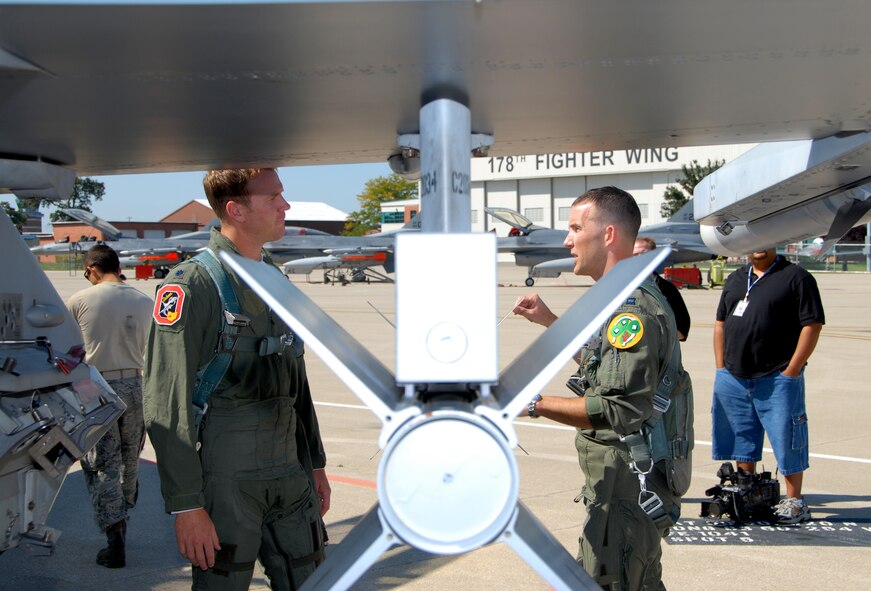 SPRINGFIELD AIR NATIONAL GUARD BASE, Ohio -- Former Ohio State University quarterback Craig Krenzel listens to Capt. Aaron "Scat" Wildman as he explains his preflight checklist prior to Mr. Krenzel's F-16 familiarization flight Sep. 11, 2009 at the 178th Fighter Wing, Springfield, Ohio. The 178th Fighter Wing trains active-duty Air Force, Air National Guard, and Air Force Reserve pilots to fly F-16 Fighting Falcons. The wing is one of three stateside National Guard units that is designated as a training unit to prepare future F-16 pilots for worldwide missions. (U.S. Air Force photo/Senior Master Sgt. Joseph R. Stahl)