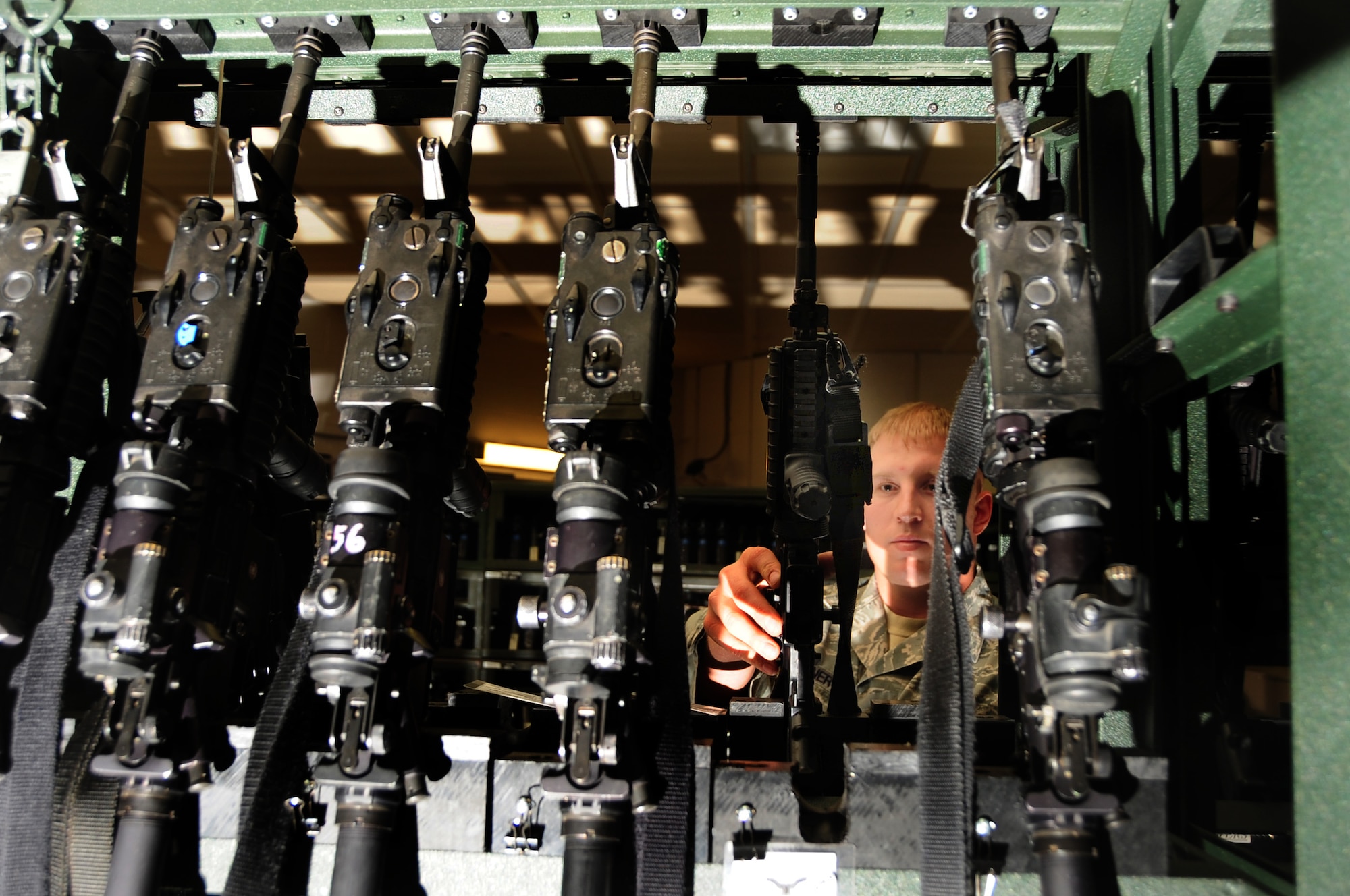 ELLSWORTH AIR FORCE BASE, S.D. -- Senior Airman Tyler Brunner, 28th Security Forces Squadron staff armory personnel, checks through multiple M-4 carbine rifles in the armory.  The armory houses any personal weapons belonging to Ellsworth members wishing to keep them out of their home. (U.S. Air Force photo/Airman 1st Class Anthony Sanchelli)

