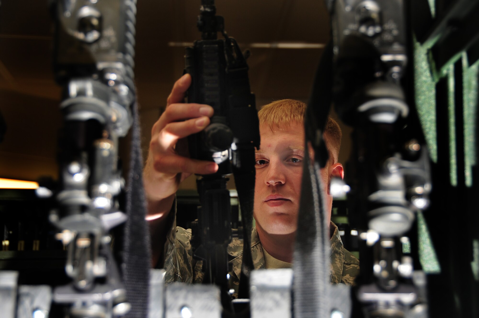 ELLSWORTH AIR FORCE BASE, S.D. -- Senior Airman Tyler Brunner, 28th Security Forces Squadron staff armorer, checks through multiple M-4 carbine rifles in the armory.  The armory houses all of the 28 SFS weapons. (U.S. Air Force photo/Airman 1st Class Anthony Sanchelli)
