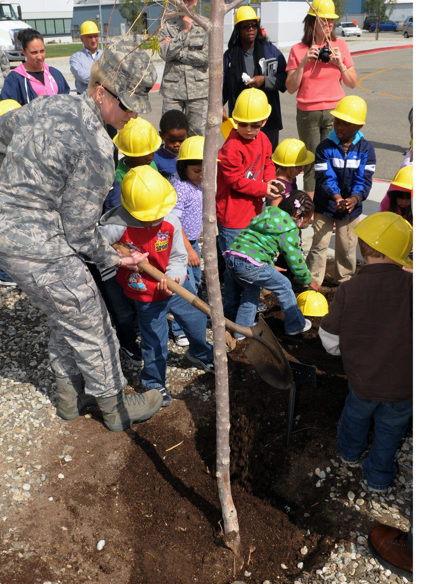 Col. Anita Latin, 61st Air Base Wing commander, and children from the Los Angeles AFB Child Development Center plant a tree to celebrate Earth Day, April 22. The tree is one of forty trees planted on active and former Air Force bases across the country in honor of the 40th Anniversary of Earth Day.  (Photo by Jim Gordon)