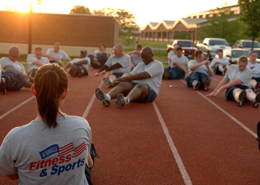 LANGLEY AIR FORCE BASE, Va. - - Staff Sgt. Cristina Sullivan, 633d Force Support Squadron fitness specialist, leads a group of Airmen in seated trunk twists during the “Back to Basics” class April 26. The eight-week course is designed to help Airmen improve their physical training performance through a rigorous daily workout program.(U.S. Air Force photo/Airman 1st Class Gul Crockett) 