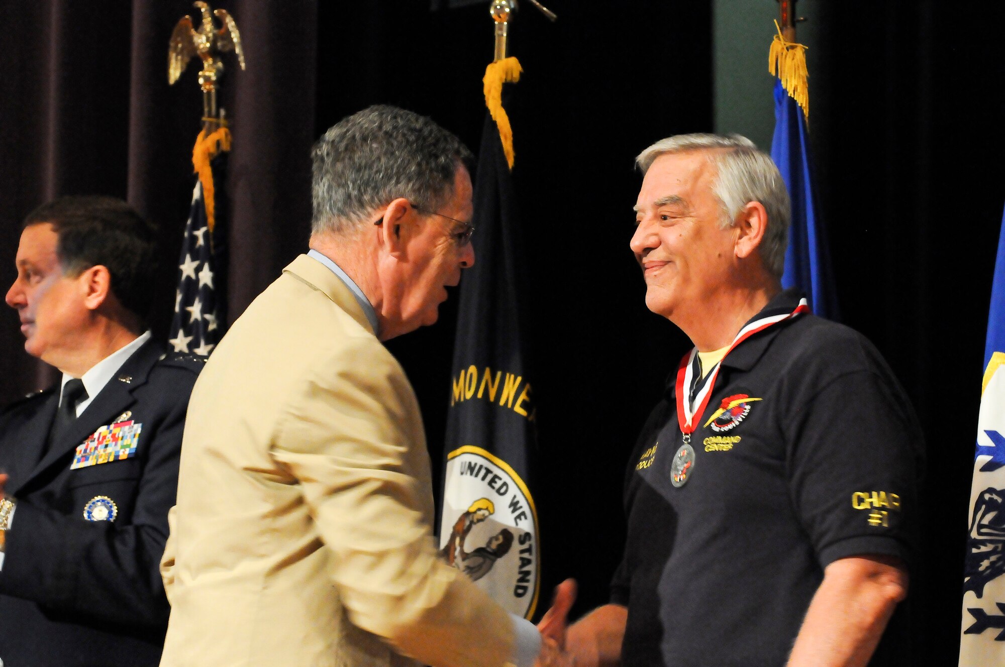 Dennis M. McCarthy, assistant secretary of defense for Reserve Affairs (left), presents Mr. Wayne Hettinger, producer of the annual Thunder Over Louisville Air Show, with a Department of Defense Centers of Influence Award during a ceremony held April 17, 2010 at Louisville Male High School in Louisville, Ky. The award recognizes individuals who have been especially supportive of military service members since Sept. 11, 2001. (U.S. Air Force photo/Tech. Sgt. Dennis Flora)
