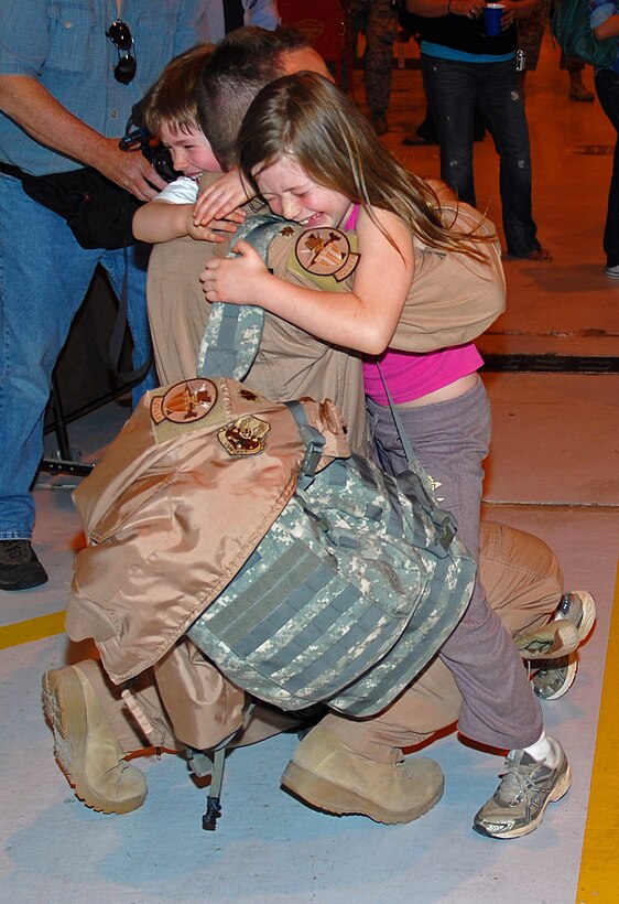 Maj. Steve Jones, 121 FS Pilot, has his hands full with daughter Clara and son Marc upon arriving home from deployment in support of Operation Iraqi Freedom, April 6. (U.S. Air Force photo by Tech Sgt. Tyrell Heaton/Released)