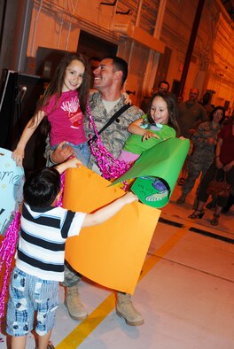 Tech Sgt. Elias Sepulveda, 113 LRS, shares the joy of coming home with daughters Emily and Emma upon his retrun from an AEF deployment to Iraq, April 6. (U.S. Air Force photo by Tech Sgt. Tyrell Heaton/Released)