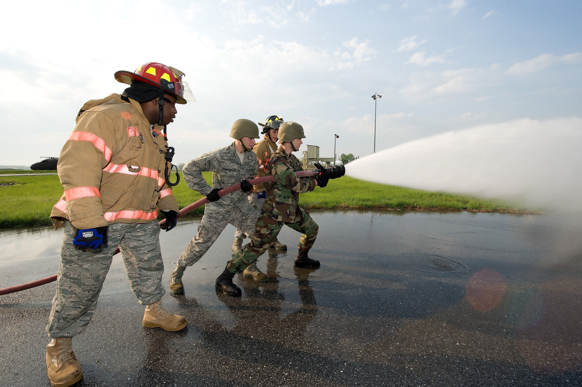 (Left) Staff Sgt. Artrail Coley, 436th Civil Engineer Squadron, teaches University of Delaware ROTC cadets how to use a fire hose during the cadets annual Field Training Exercise held at Dover Air Force Base April 16. (U.S Air Force Photo/Jason Minto)