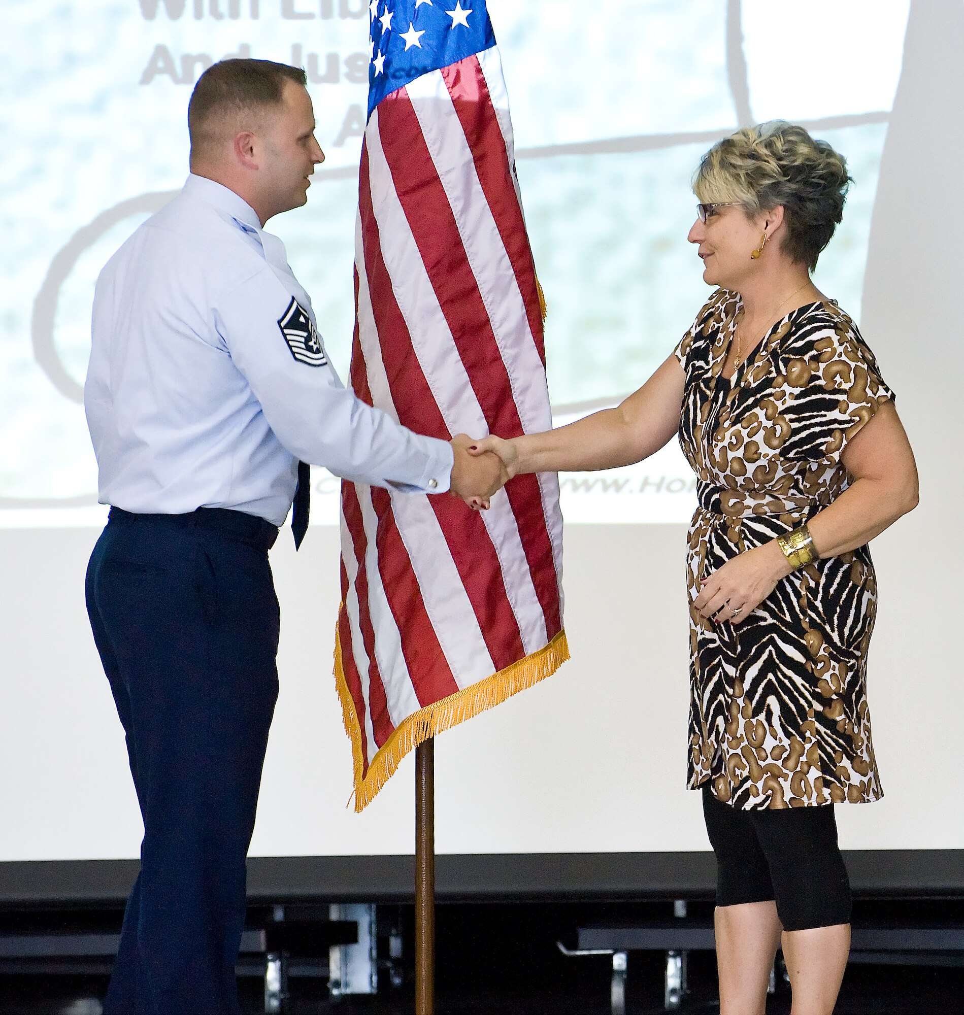 Master Sgt. Richard A. Bryant II, 736th Aircraft Maintenance Squadron first sergeant, shakes hands with the Principal of South Dover Elementary School, Mrs. Marian Wolak, during the flag donation ceremony presentation April 16. (U.S Air Force photo/Roland Balik)