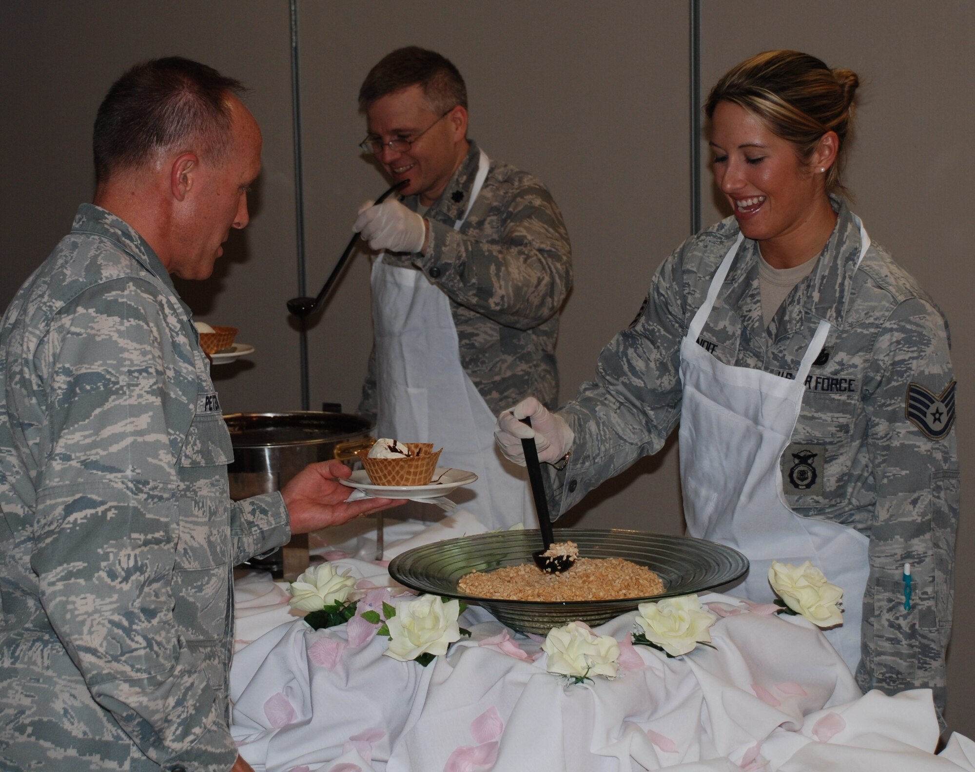 LAUGHLIN AIR FORCE BASE, Texas – Lt. Col. Kirk Phillips, 47th Medical Support Squadron commander, and Staff Sgt. Erica Benoit, 47th Security Forces Squadron, put the finishing touches on Col. Bruce Peters’, 47th Medical Group commander, ice-cream dish at the Volunteer Appreciation Ice Cream Social at Club XL April 22.  Andia Dinesen, spouse of Capt. Ian Dinesen, 47th Security Forces Squadron commander, was named Laughlin’s volunteer of the year and Laughlin members were recognized for donating more than 3,697 hours of their time, which saved the Air Force more than $77,000. (U.S. Air Force photo by Airman 1st Class Blake Mize)
