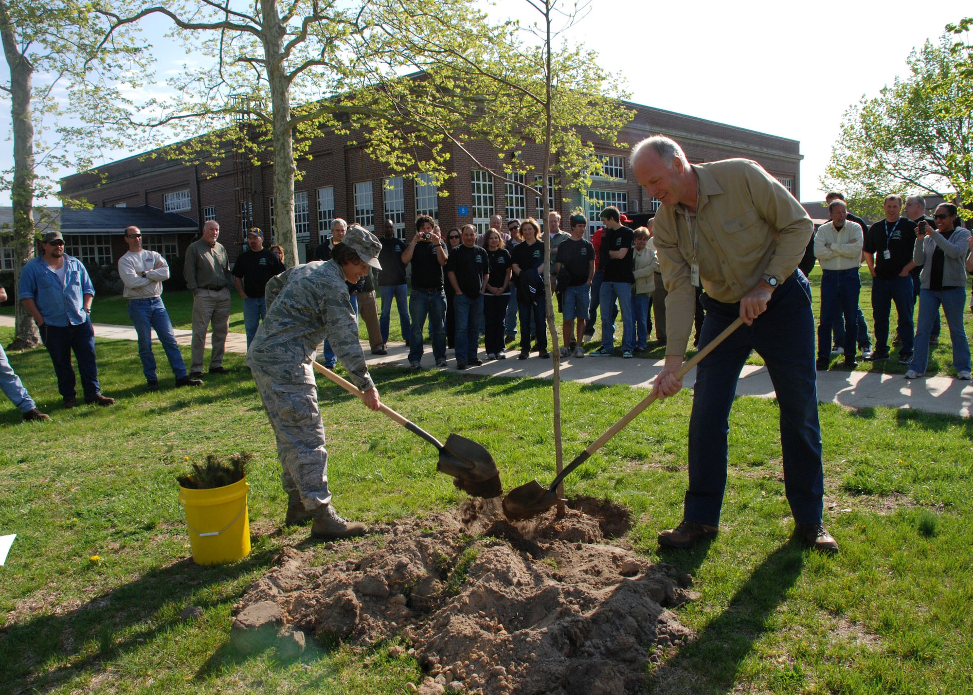 Col. Gina Grosso, Joint Base McGuire-Dix-Lakehurst commander, and John Joyce, Lakehurst natural resources officer, plant a Sassafras tree as part of of the Lakehurst Earth Day opening ceremony.The Sassafras tree is the only tree in New Jersey that grows three different types of leaves. The leaves represent the three services making up JB MDL. (U.S. Navy photo/Sherri Jacobs). 