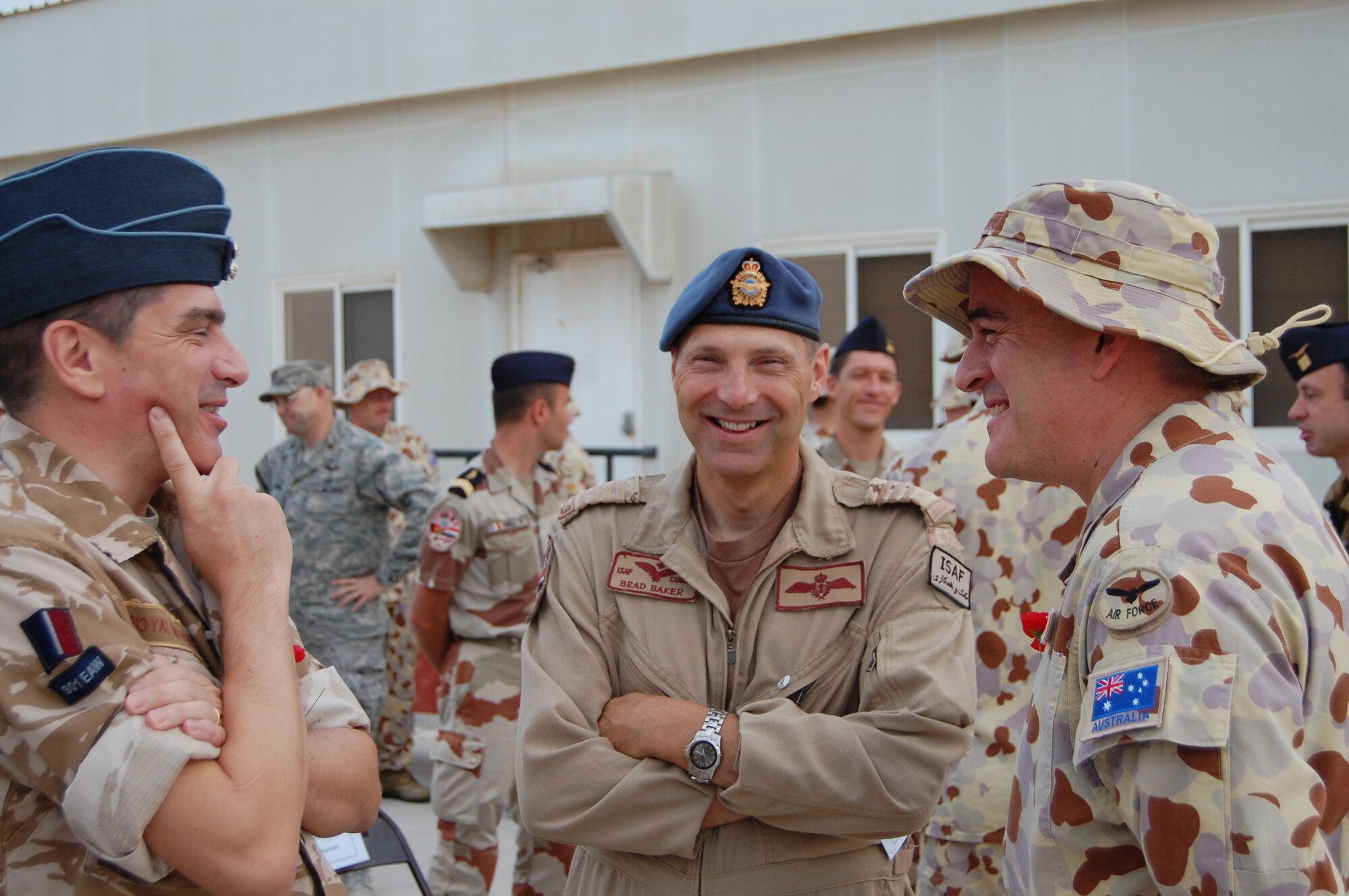 Group Captain Brad Baker, Canadian Air Force, talks with his British and Australian colleagues after the Australian and New Zealand Army Corps Day dawn service in Southwest Asia April 25, 2010. (U.S. Air Force photo/Maj. Chad Steffey/released)