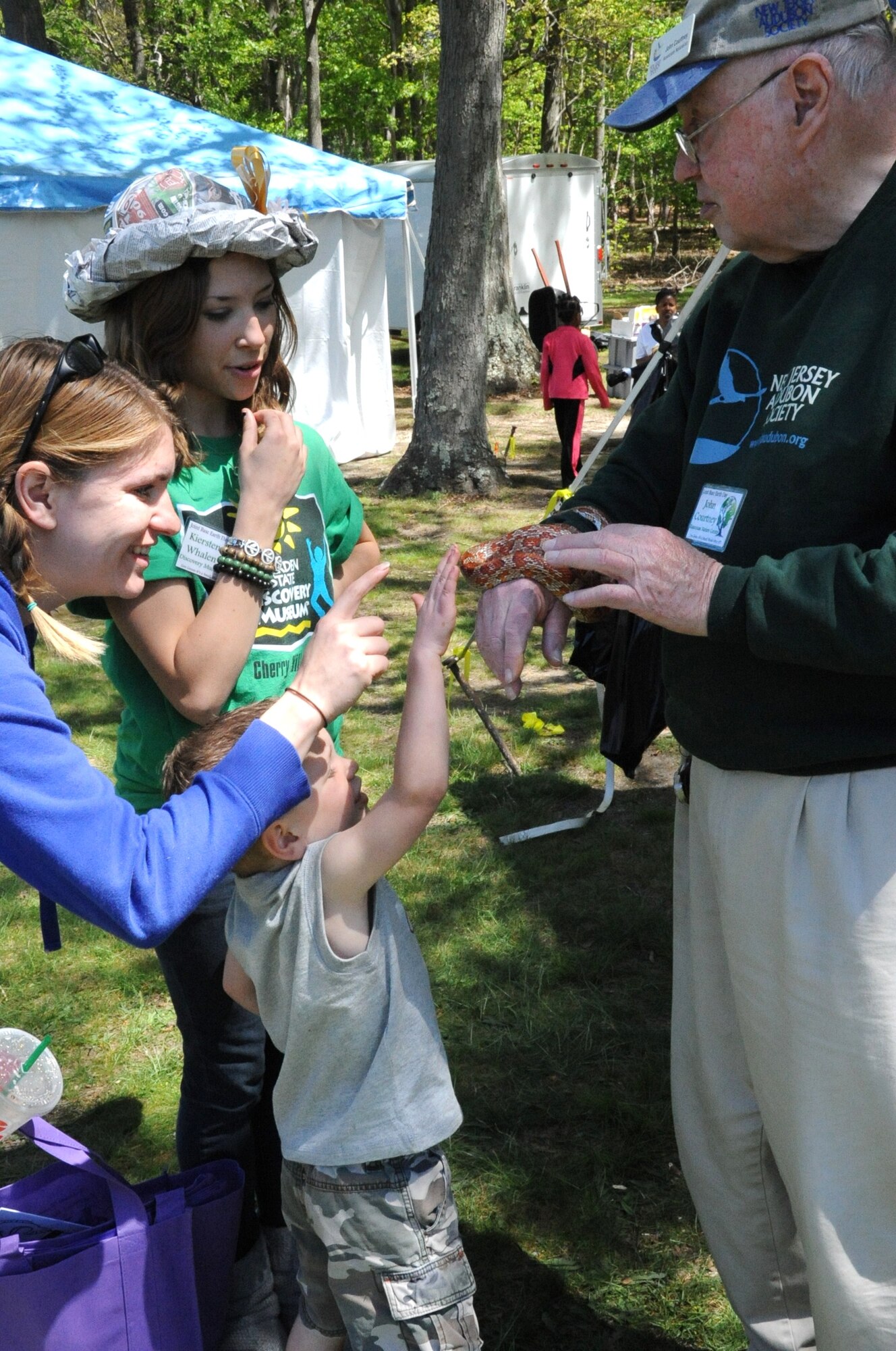John Courtney, Rancocas Nature Center, explains the environment and habits of a corn snake to Kiersten Whalen, from the Discovery Museum, and Jenna and Colton Ratlief, wife and son of James Ratlief, an 87th Civil Engineering Squadron firefighter. Earth Day was celebrated April 24 on Laurel Pond here. (U.S. Air Force photo/2nd. Lt. Carolyn Glover)