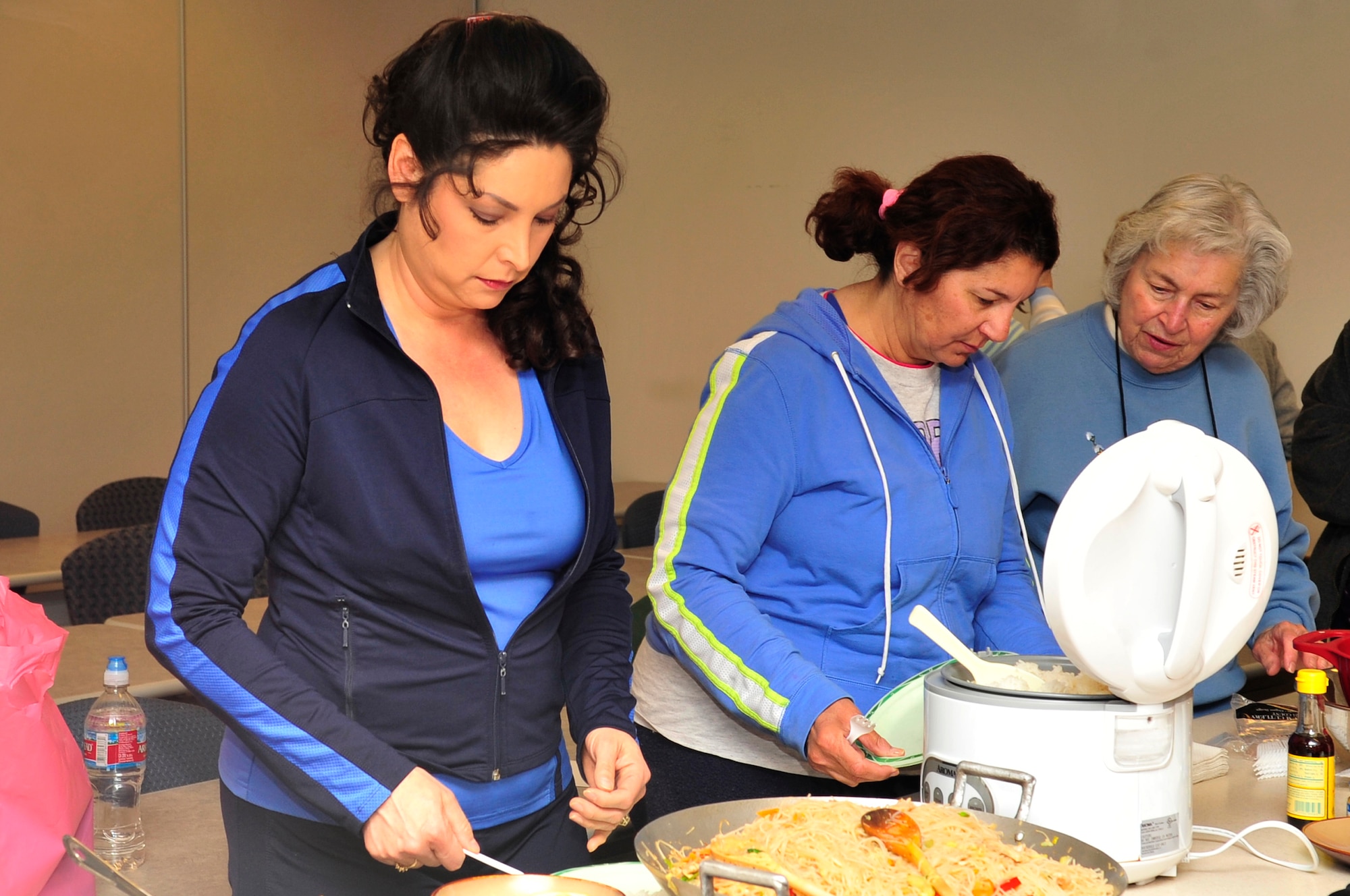 BUCKLEY AIR FORCE BASE, Colo.-- Team Buckley members Susan Mann, Allegra Reynolds and Angelina Mann serve up traditional Filipino food made for the Month of the Military Child cooking class April 23 at the Health and Wellness Center. (U.S. Air Force Photo by Airman 1st Class Manisha Vasquez)