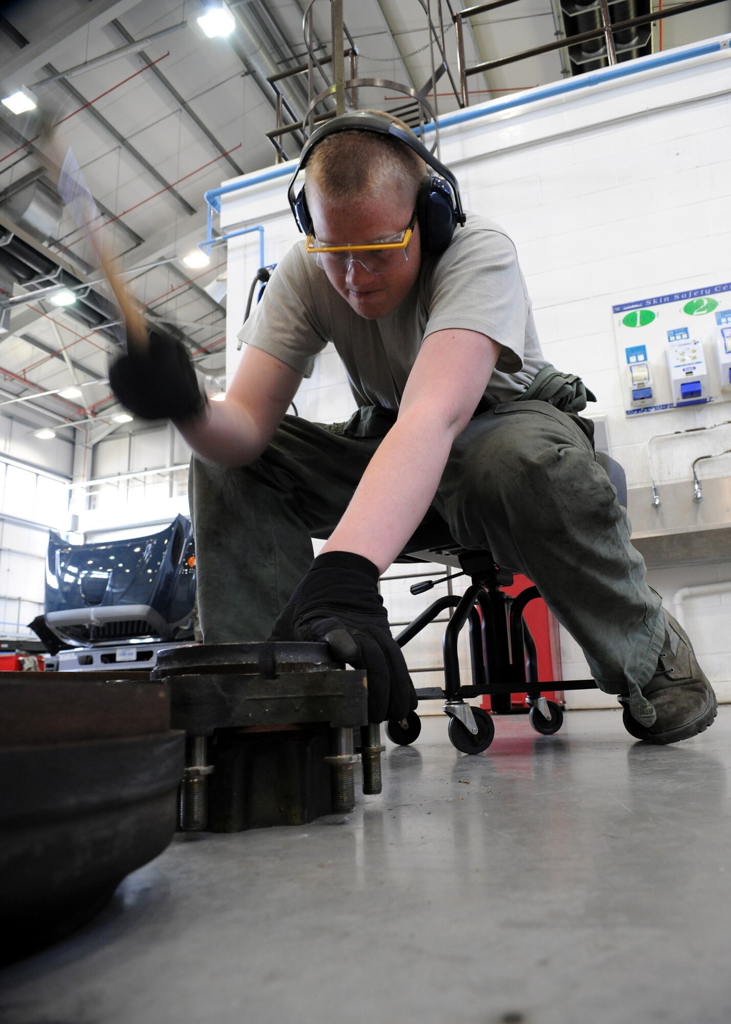 RAF MILDENHALL, England – Senior Airman Neil Kohan, 100th Logistics Readiness Squadron vehicle maintenance technician, hammers out bolts while disassembling a forklift wheel hub April 23. (U.S. Air Force photo/ Staff Sgt. Jerry Fleshman)