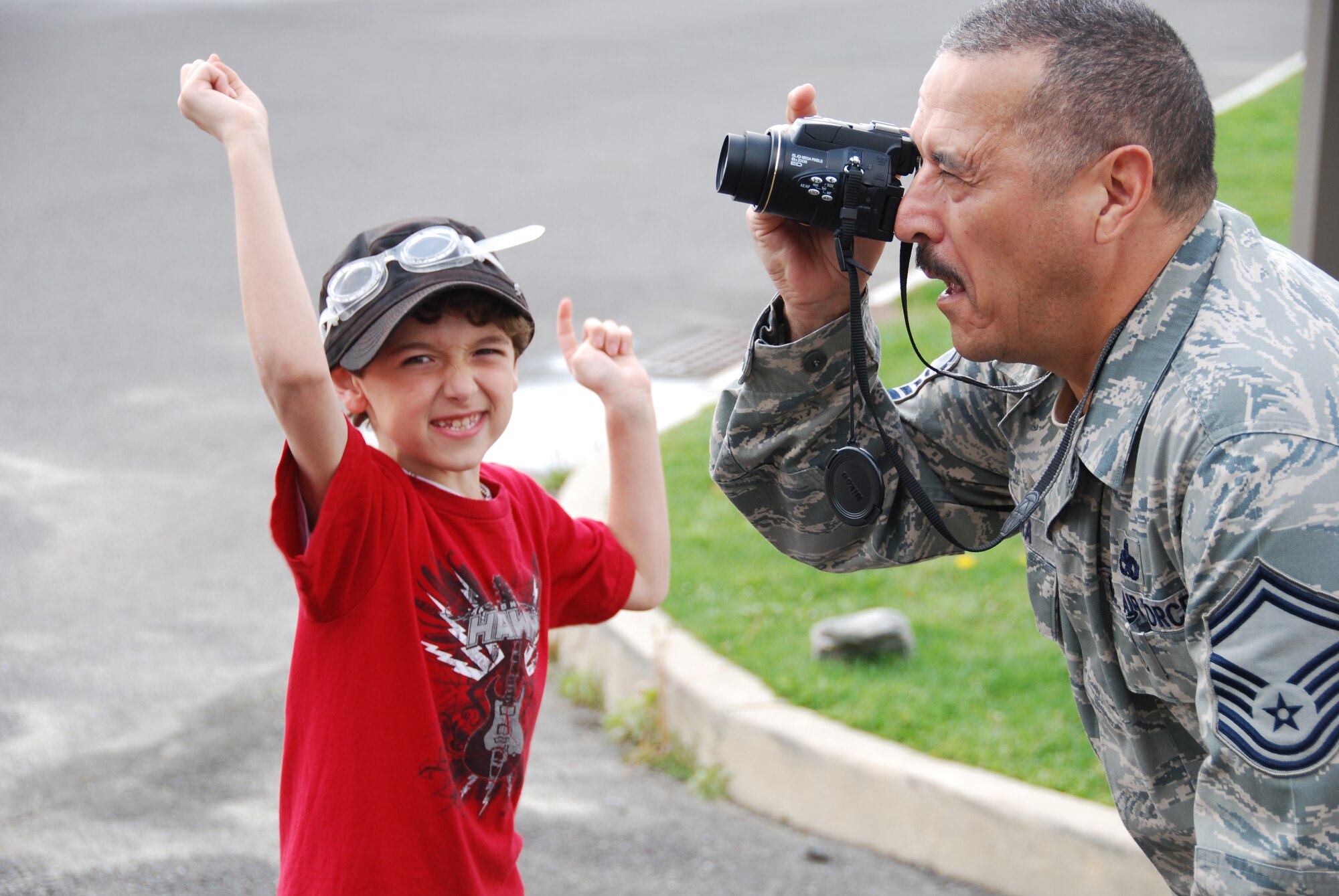 JOINT BASE MCGUIRE-DIX-LAKEHURST, N.J. - Senior Master Sgt. Oswaldo Cabrera of the 514th Maintenance Squadron, takes a picture of the fire truck demonstration while his son cheers. The fire department here, was one of several sites more than 60 members visited April 22 during National Bring Your Child to Work Day. (U.S. Air Force photo/Master Sgt. Donna T. Jeffries)
